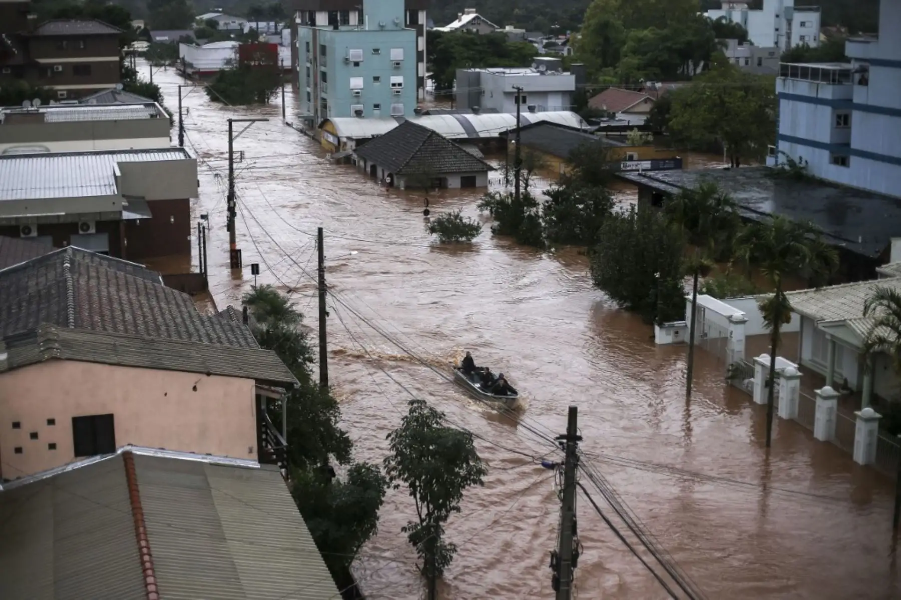 Los voluntarios utilizan un barco pesquero para rescatar a los residentes atrapados dentro de sus casas en el centro de la ciudad de Sao Sebastiao do Cai, estado de Rio Grande do Sul, Brasil, el 2 de mayo de 2024. El número de muertos por una tormenta severa en Rio Grande do Sul, en el sur Brasil, ascendió al puesto 13, en medio del "peor desastre" en la historia del estado al que viajó el jueves el presidente Luiz Inácio Lula da Silva. (Foto de Anselmo Cunha / AFP)