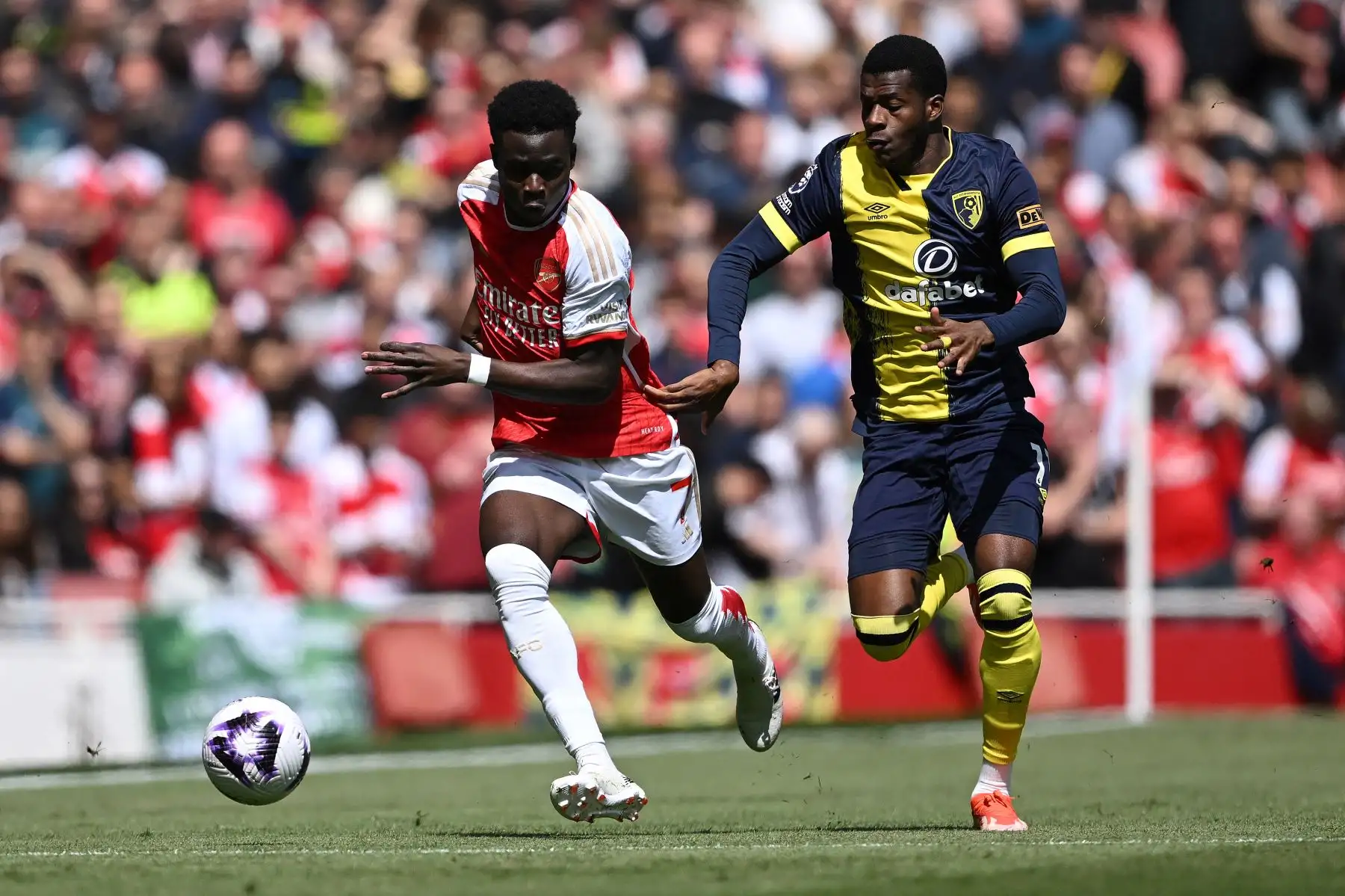 El delantero burkinés de Bournemouth Dango Ouattara compite con el centrocampista inglés del Arsenal  Bukayo Saka durante el partido de fútbol de la Premier League inglesa entre Arsenal y Bournemouth. Foto: ANDINA/AFP
