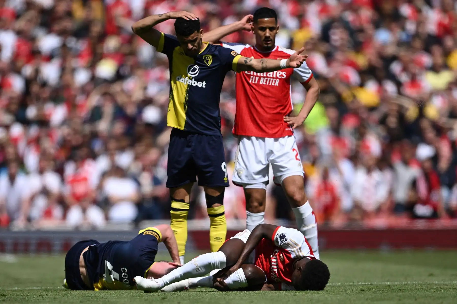 El centrocampista inglés del Arsenal Bukayo Saka se encuentra en el campo después de chocar con el centrocampista inglés del Bournemouth Lewis Cook  durante el partido de fútbol de la Premier League inglesa entre el Arsenal y Bournemouth. Foto: ANDINA/AFP