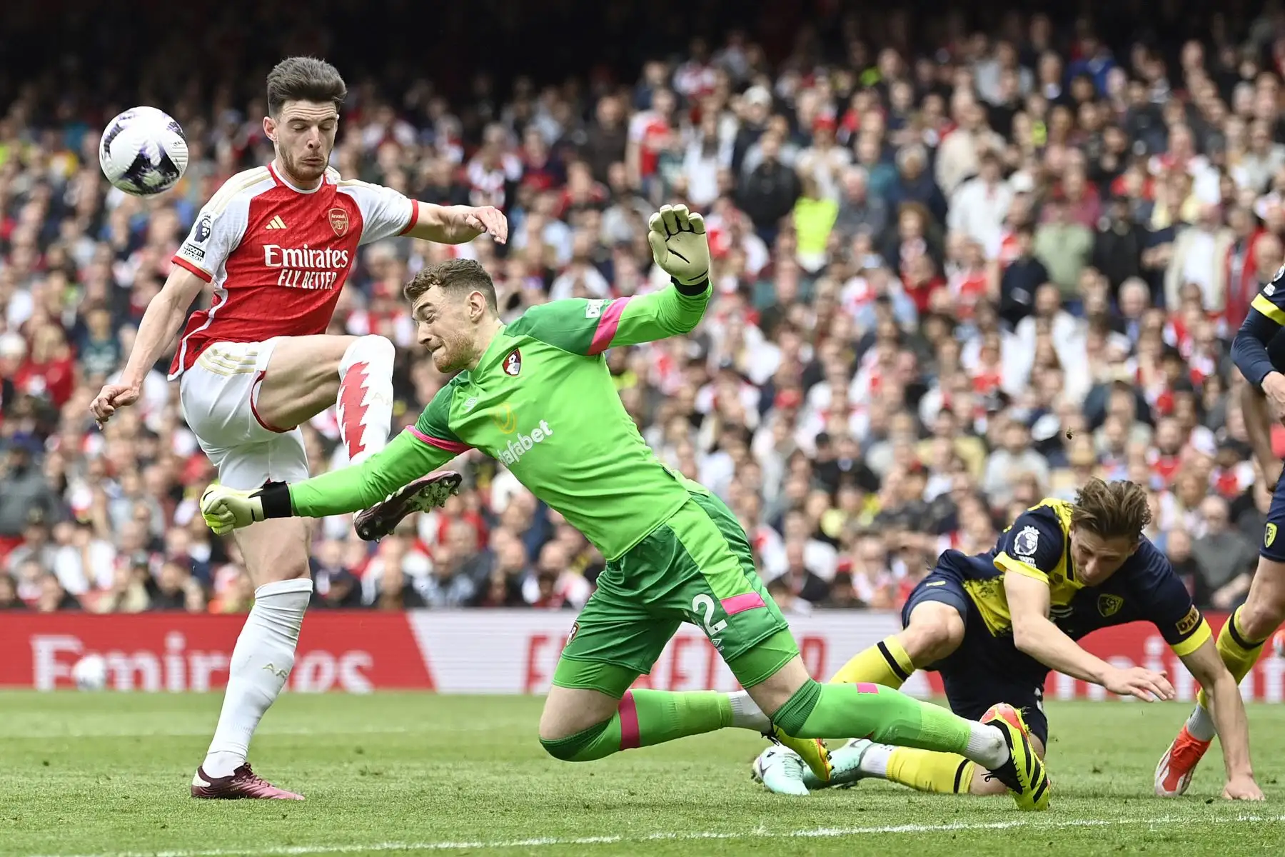 El portero irlandés de Bournemouth Mark Travers  choca con el mediocampista inglés del Arsenal Declan Rice mientras salva durante el partido de fútbol de la Premier League inglesa entre Arsenal y Bournemouth. Foto: ANDINA/ AFP