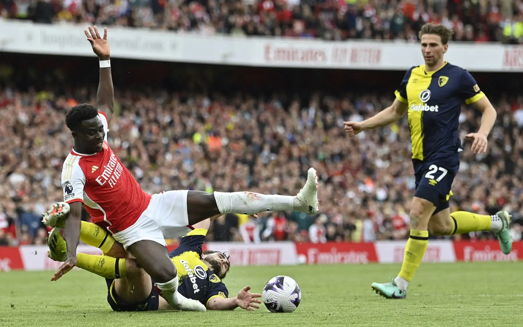 Saka cae al suelo tras una entrada del defensor argentino del Bournemouth  Marcos Senesi durante el partido de fútbol de la Premier League inglesa entre Arsenal y Bournemouth. Foto: ANDINA/AFP