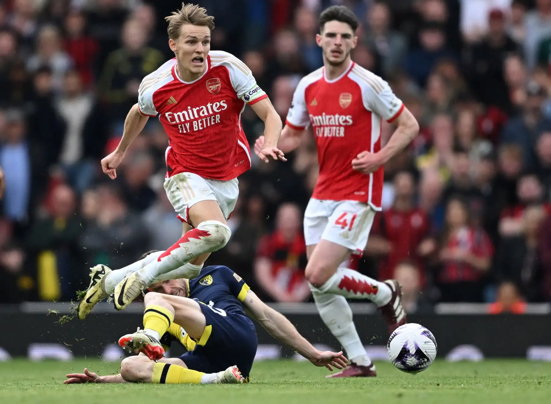 El mediocampista noruego del Arsenal Martin Odegaard evita un desafío del mediocampista escocés del Bournemouth  Ryan Christie durante el partido de fútbol de la Premier League inglesa entre el Arsenal y Bournemouth. 
Foto: ANDINA/AFP