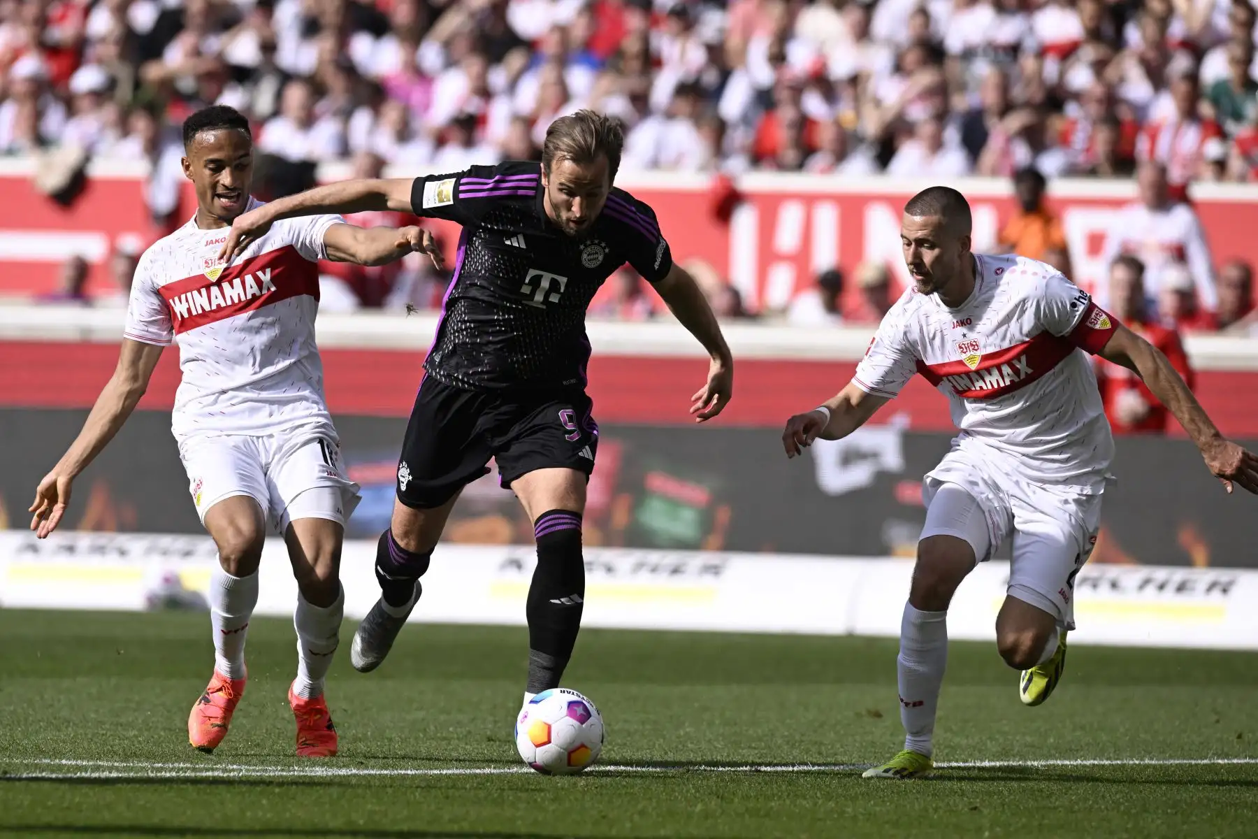 El delantero inglés del Bayern de Múnich Harry Kane compite por el balón con el delantero alemán del Stuttgart  Jamie Leweling y el defensor alemán del Stuttgart  Waldemar Anton durante el partido de fútbol de la primera división alemana de la Bundesliga entre el VfB Stuttgart y el FC Bayern Munich. 
Foto: ANDINA/ AFP