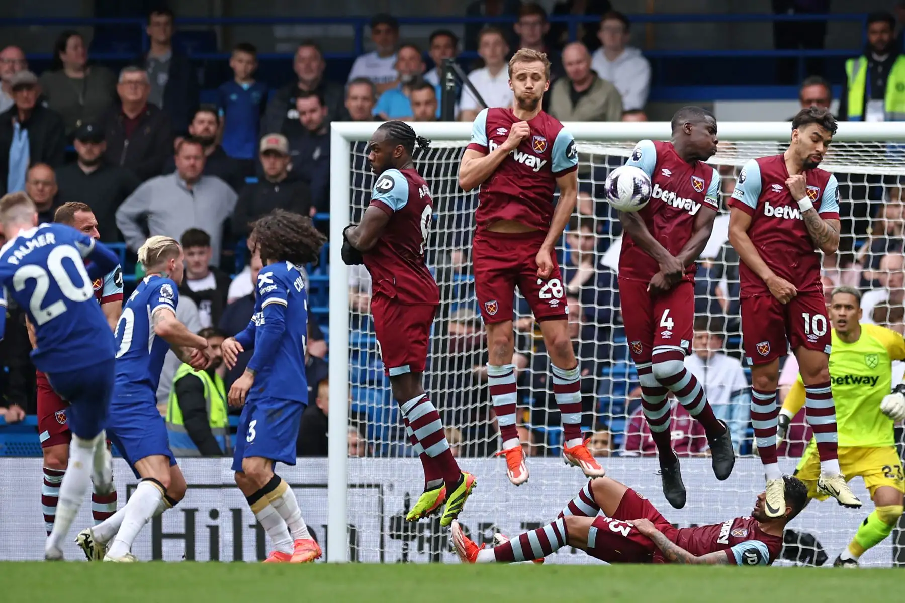 El mediocampista inglés del Chelsea Cole Palmer toma un tiro libre, pero el balón golpea al defensor francés del West Ham United  Kurt Zouma en la pared durante el partido de fútbol de la Premier League inglesa entre Chelsea y West Ham United. 
Foto: ANDINA/AFP