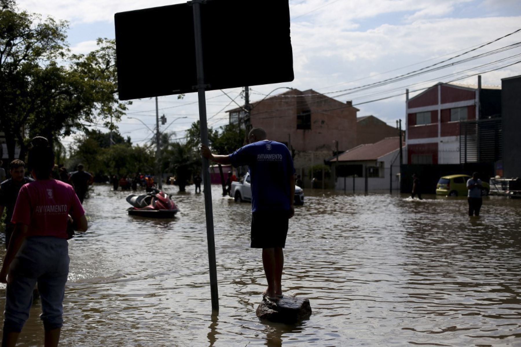 A man watches as neighbors rescued from their flooded homes are transported at the Sarandi neighborhood in Porto Alegre, Rio Grande do Sul state, Brazil, on May 5, 2024. The challenge is titanic and against the clock: authorities and neighbours are trying to avoid an even greater tragedy than the one already experienced in the Brazilian state of Rio Grande do Sul, where 66 people died and 80,000 were displaced by the floods, according to the authorities. Foto: AFP