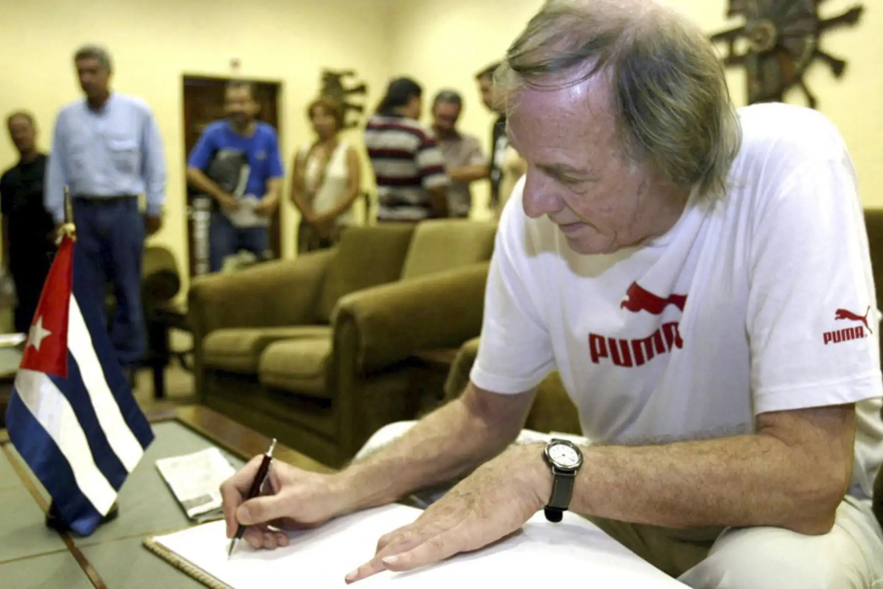 Cesar Luis Menotti, ex director técnico del seleccionado argentino de fútbol, firmó el libro de visitas el 08 de octubre de 2005 al Conjunto Monumentario Ernesto Guevara en Santa Clara. Lo acompaña Roberto López Hernández, primer secretario del Partido Comunista local. Foto: AFP