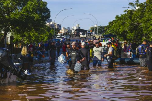 Esta imagen publicada por el Ayuntamiento de Porto Alegre (PMPA) muestra a un grupo de voluntarios en una calle inundada. Foto: AFP.