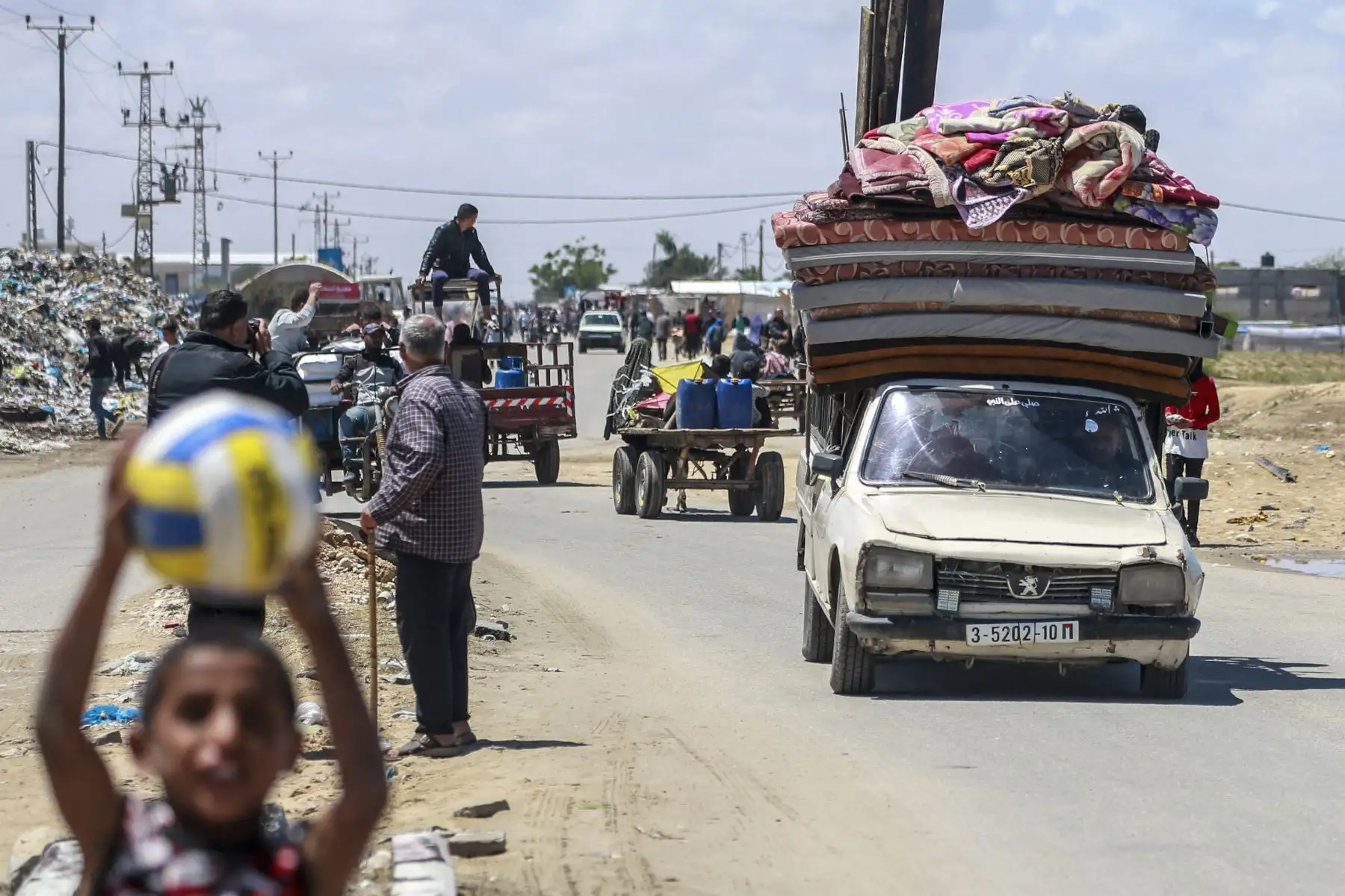 Palestinos desplazados que partieron con sus pertenencias desde Rafah, en el sur de la Franja de Gaza, tras una orden de evacuación del ejército israelí, llegan a Khan Yunis, en medio del conflicto en curso entre Israel y el movimiento palestino Hamas.
Foto: AFP