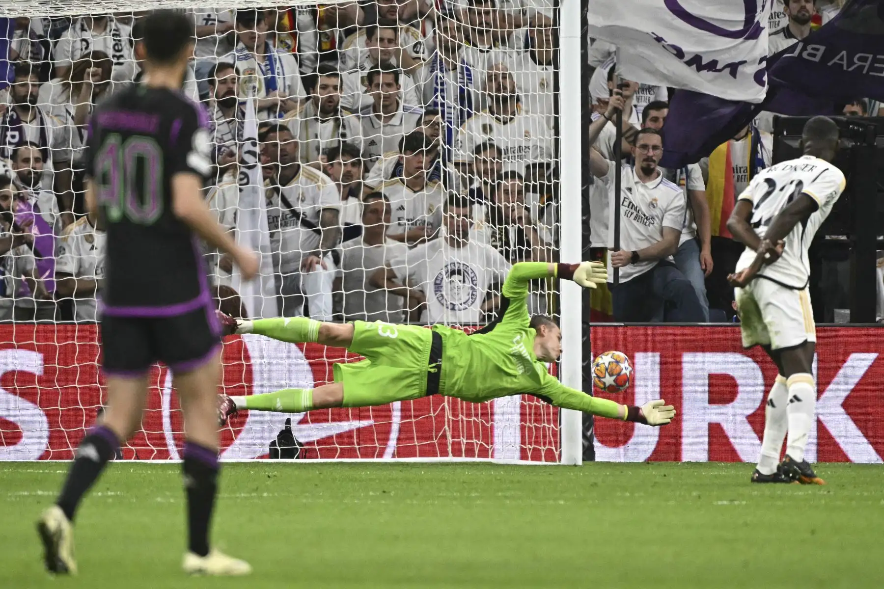 El portero ucraniano del Real Madrid, Andriy Lunin concede el gol inicial marcado por el mediocampista canadiense del Bayern Munich,  Alphonso Davies durante el partido de vuelta de las semifinales de la Liga de Campeones de la UEFA entre el Real Madrid CF y el FC Bayern Munich en el estadio Santiago Bernabeu de Madrid.
Foto: AFP
