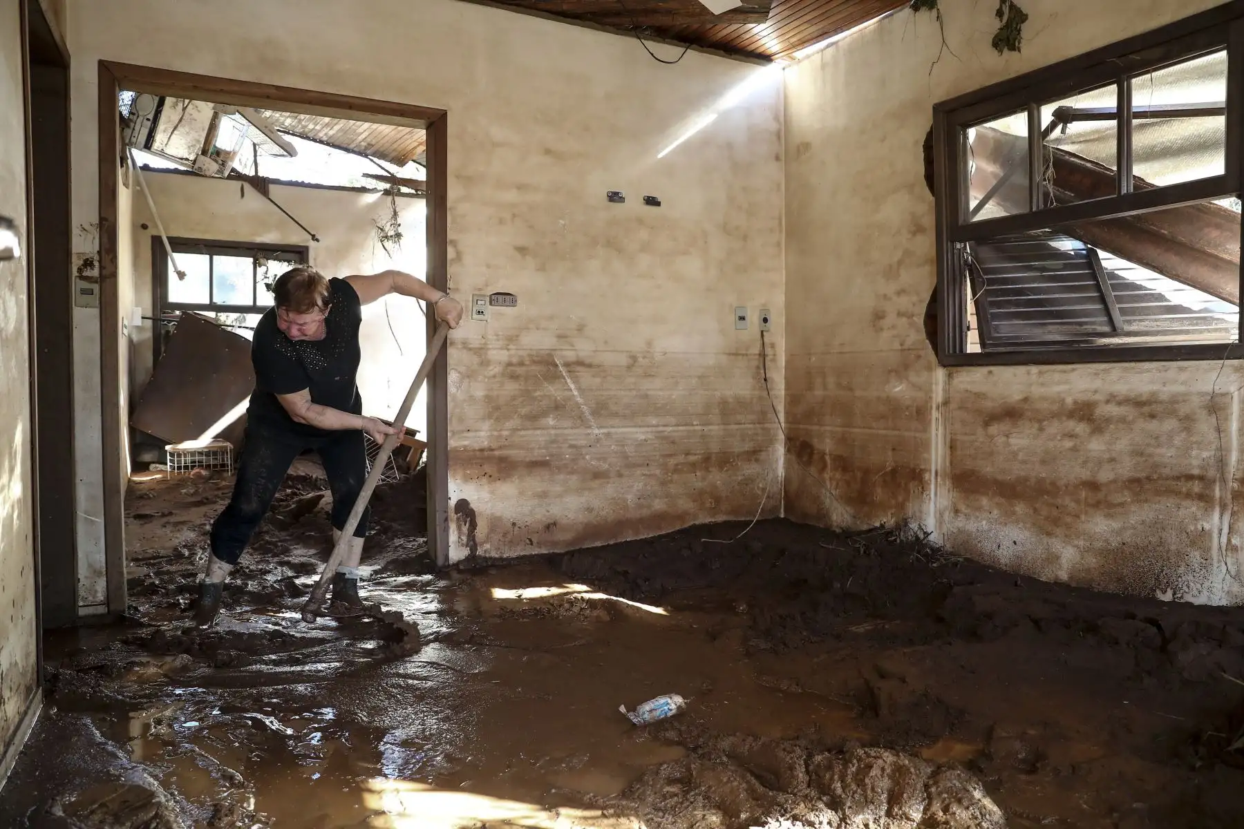 La brasileña Maria Olbermann, de 65 años de edad, limpia su casa tras el desbordamiento del río Taquari por las inundaciones en Cruzeiro do Sul, estado de Rio Grande do Sul, en Brasil. Foto: EFE