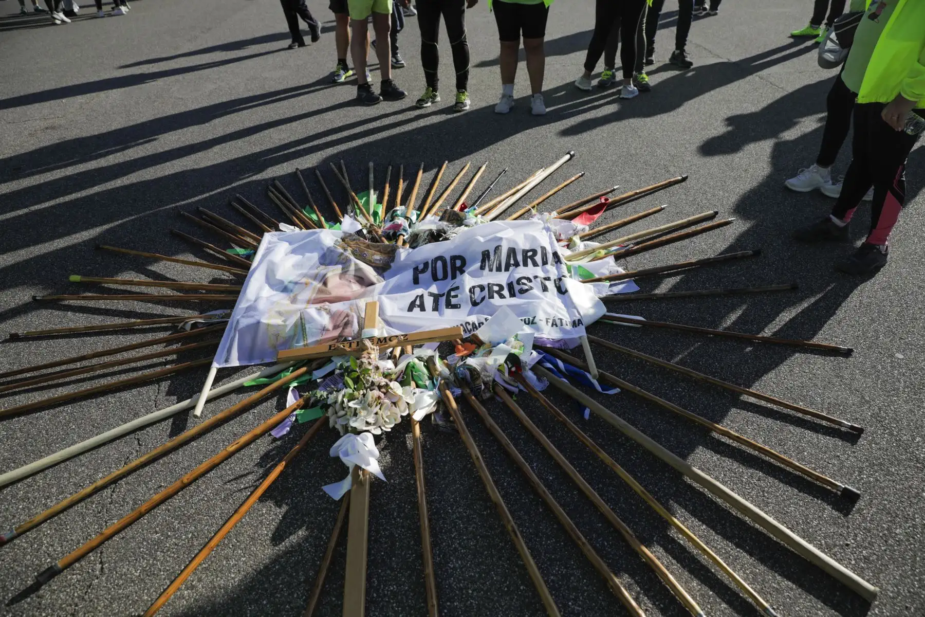 Un cartel que dice "A través de María a Cristo" yace en el suelo mientras los peregrinos participan en las ceremonias religiosas de la peregrinación del 13 de mayo al Santuario de Fátima en Ourem, Portugal. Foto:EFE