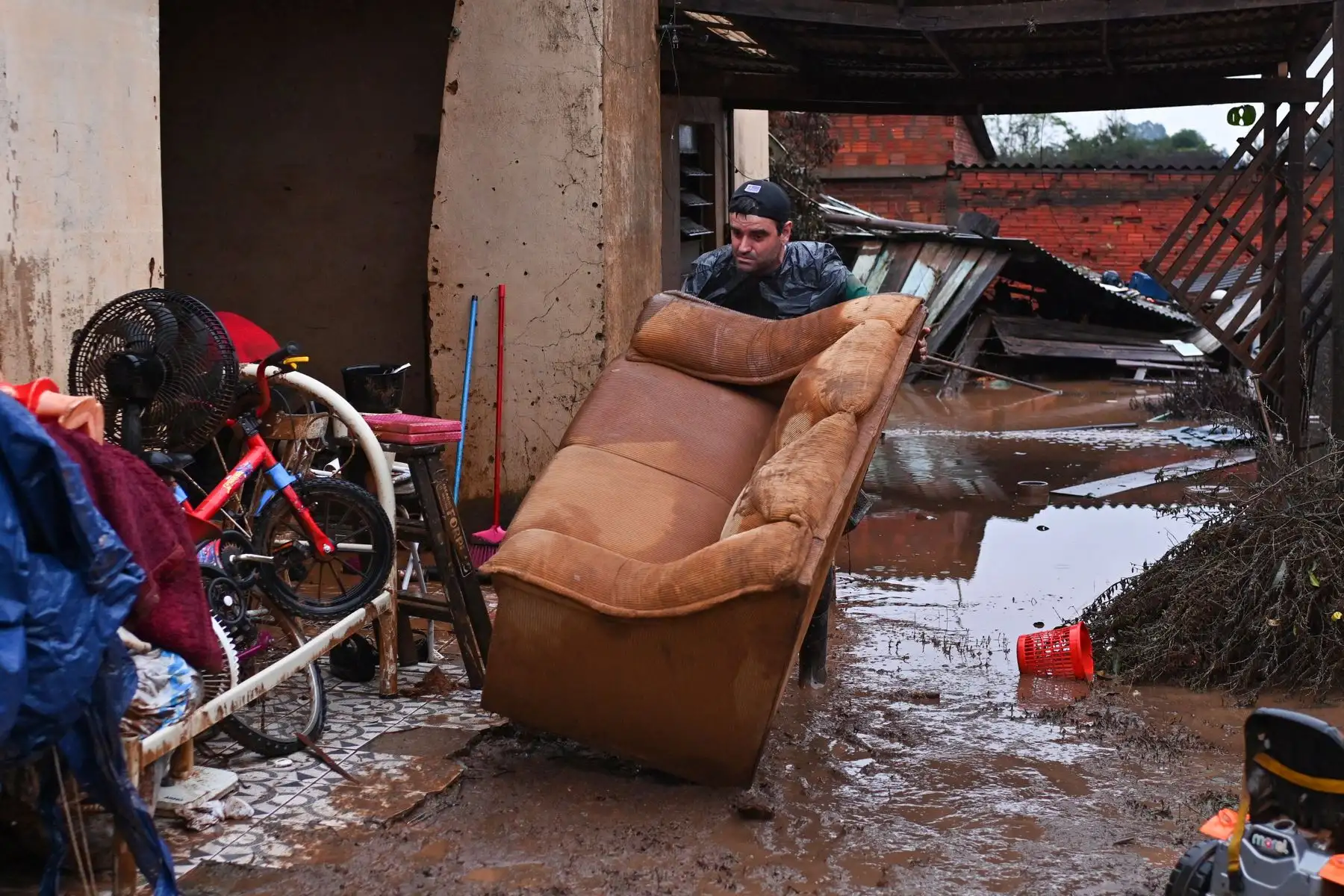 Everton Lemes intenta rescatar un sofá afectados por una inundación este domingo en el municipio de Río Pardo, estado de Rio Grande do Sul (Brasil). La tragedia que se vive en el sur de Brasil, donde las inundaciones por las fuertes lluvias que azotan la región desde hace dos semanas ya han dejado 144 muertos y 125 desaparecidos, puede empeorar en las próximas horas debido a la crecida de los ríos por los temporales de este domingo. Foto: EFE
