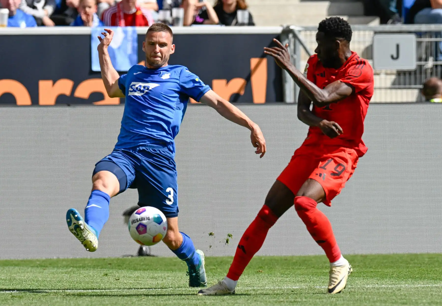 El defensor checo del Hoffenheim Pavel Kaderabek y el mediocampista canadiense del Bayern Munich Alphonso Davies compiten por el balón durante el partido de fútbol de la primera división alemana de la Bundesliga entre el TSG 1899 Hoffenheim y el FC Bayern Munich. Foto: ANDINA/AFP