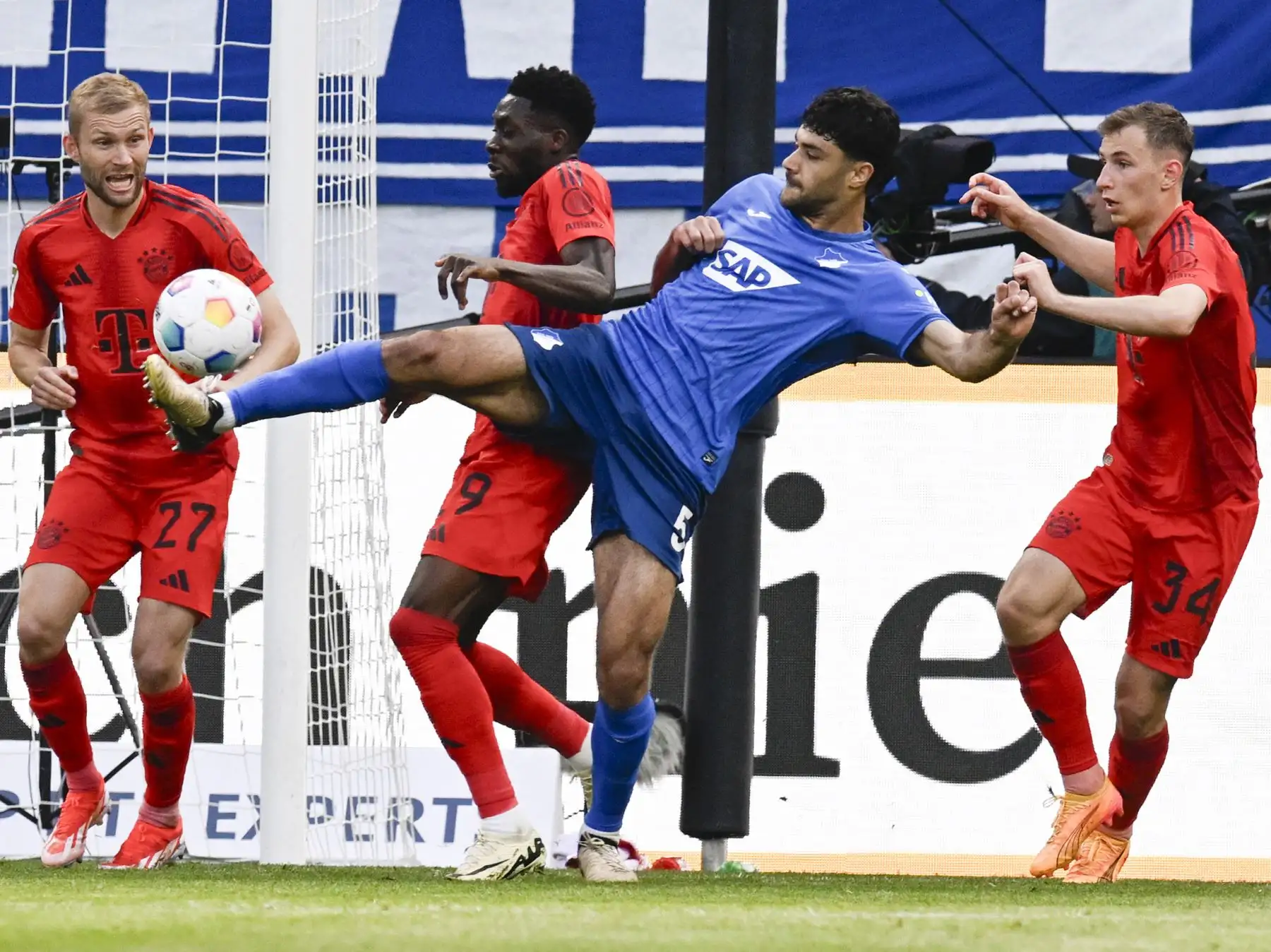 El defensor turco del Hoffenheim Ozan Kabak  y el mediocampista canadiense del Bayern Munich Alphonso Davies compiten por el balón durante el partido de fútbol de la primera división alemana de la Bundesliga entre el TSG 1899 Hoffenheim y el FC Bayern Munich. Foto: ANDINA/AFP