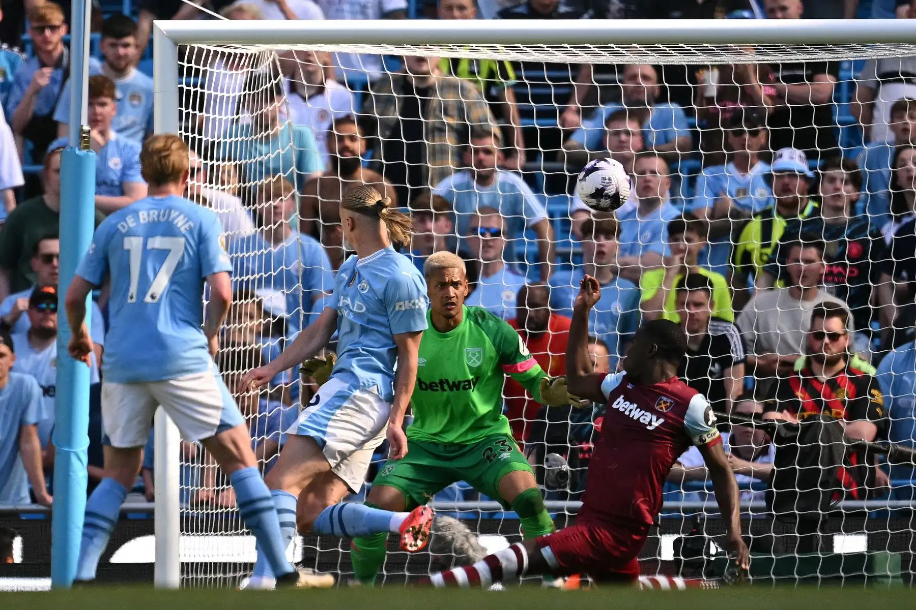 El portero francés del West Ham United  Alphonse Areola observa como un disparo del delantero noruego del Manchester City Erling Haaland pasa por encima de la barra durante el partido de fútbol de la Premier League inglesa entre Manchester City y West Ham United. Foto: ANDINA/AFP