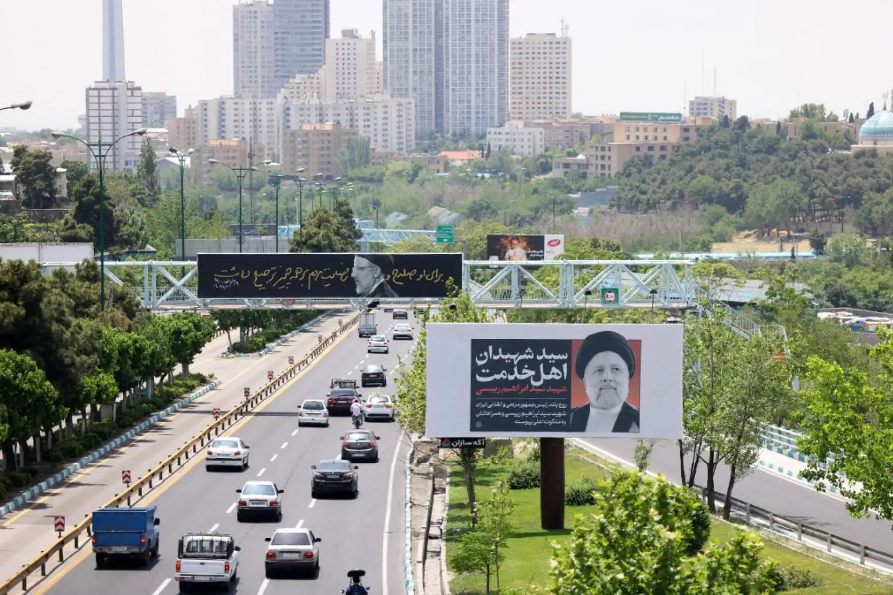 El tráfico pasa junto a pancartas con retratos del difunto presidente de Irán, Ebrahim Raisi, en el centro de Teherán, mientras los dolientes en la ciudad nororiental de Tabriz asistían a una procesión fúnebre por el presidente y su séquito, que murieron en un accidente de helicóptero hace dos días. Foto: ANDINA/AFP