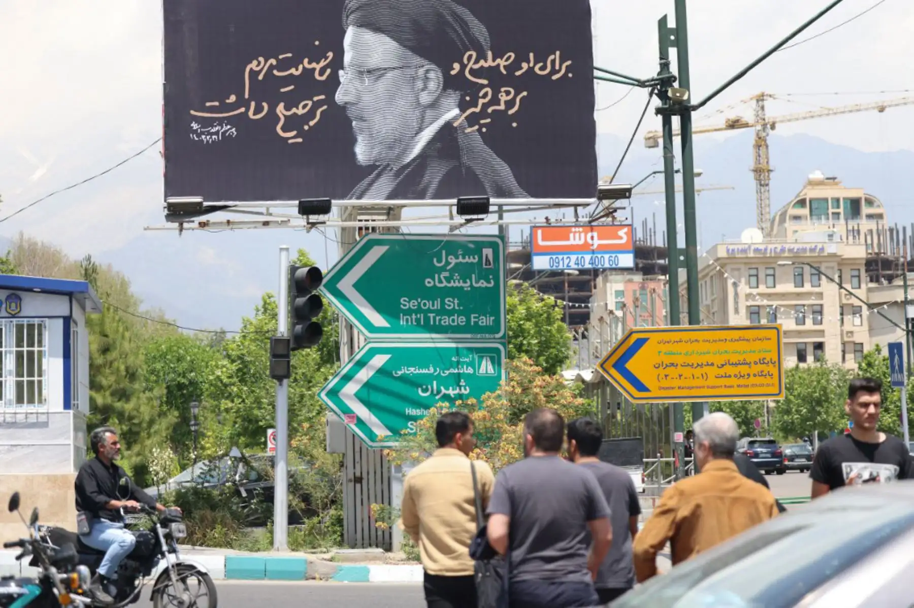 La gente cruza una calle frente a un cartel con un retrato del difunto presidente de Irán, Ebrahim Raisi, en el centro de Teherán, mientras los dolientes en la ciudad nororiental de Tabriz asistían a una procesión fúnebre por el presidente y su séquito que fueron asesinados en un accidente de helicóptero hace dos días. 
Foto: ANDINA/AFP