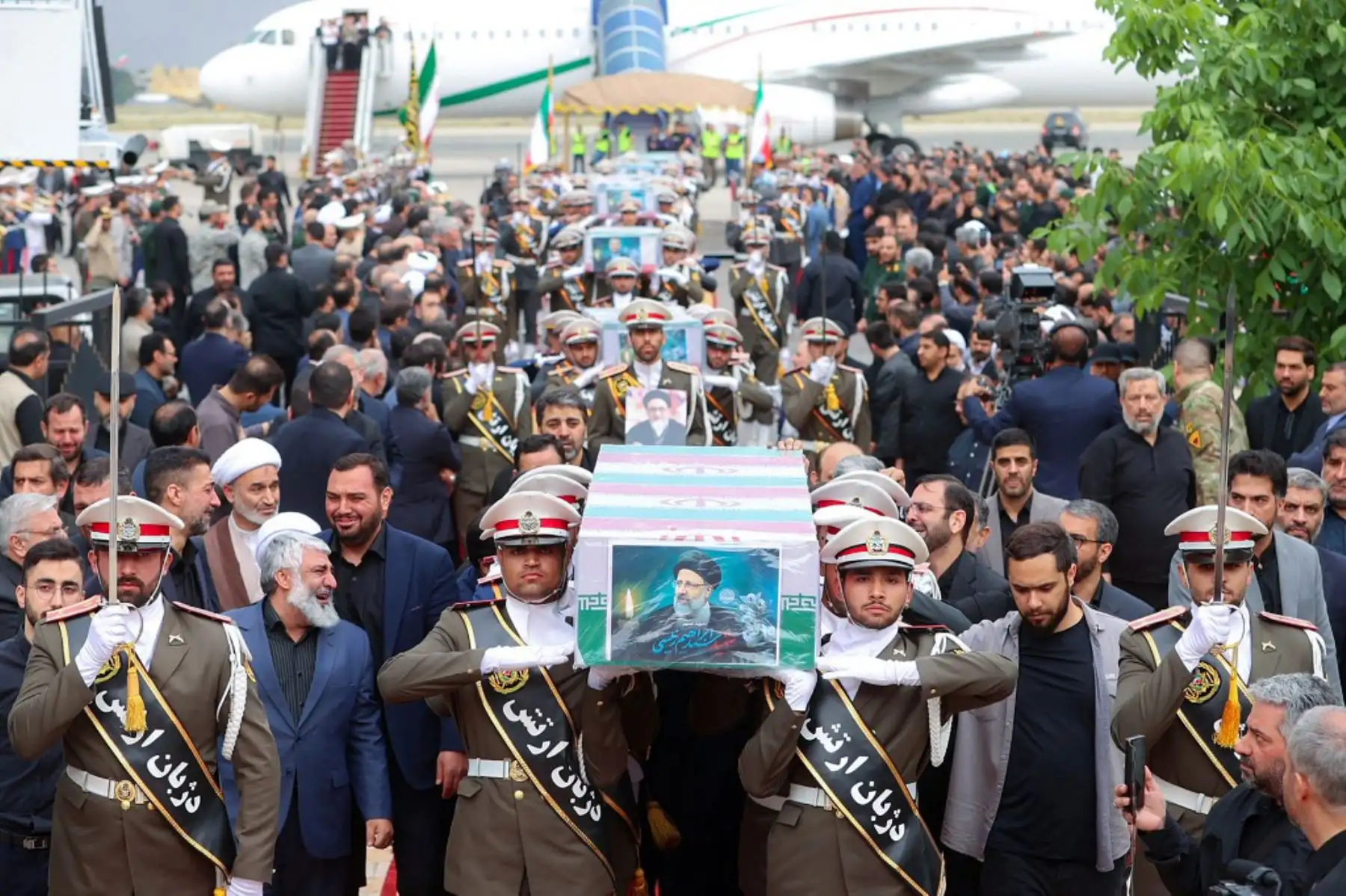 Esta imagen proporcionada por la oficina del presidente iraní muestra a guardias de honor llevando los ataúdes del difunto presidente de Irán, Ebrahim Raisi, el ministro de Relaciones Exteriores Hossein Amir-Abdollahian y otros durante una procesión fúnebre en el aeropuerto de Mehrabbad en Teherán.  Foto: ANDINA/ AFP