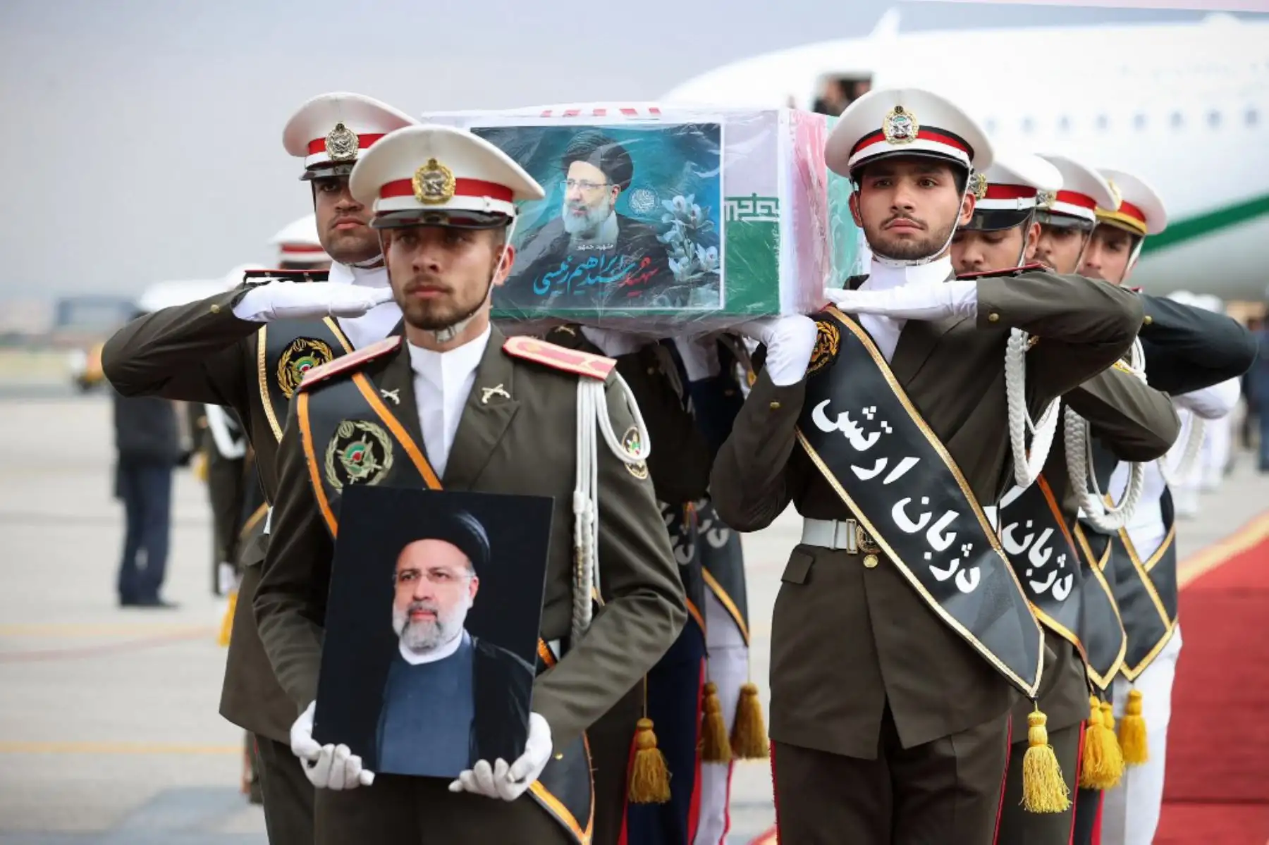 Esta fotografía proporcionada por la oficina del presidente iraní muestra a guardias de honor llevando el ataúd del difunto presidente Ebrahim Raisi durante una procesión fúnebre en el aeropuerto de Mehrabbad en Teherán. Foto. ANDINA/AFP