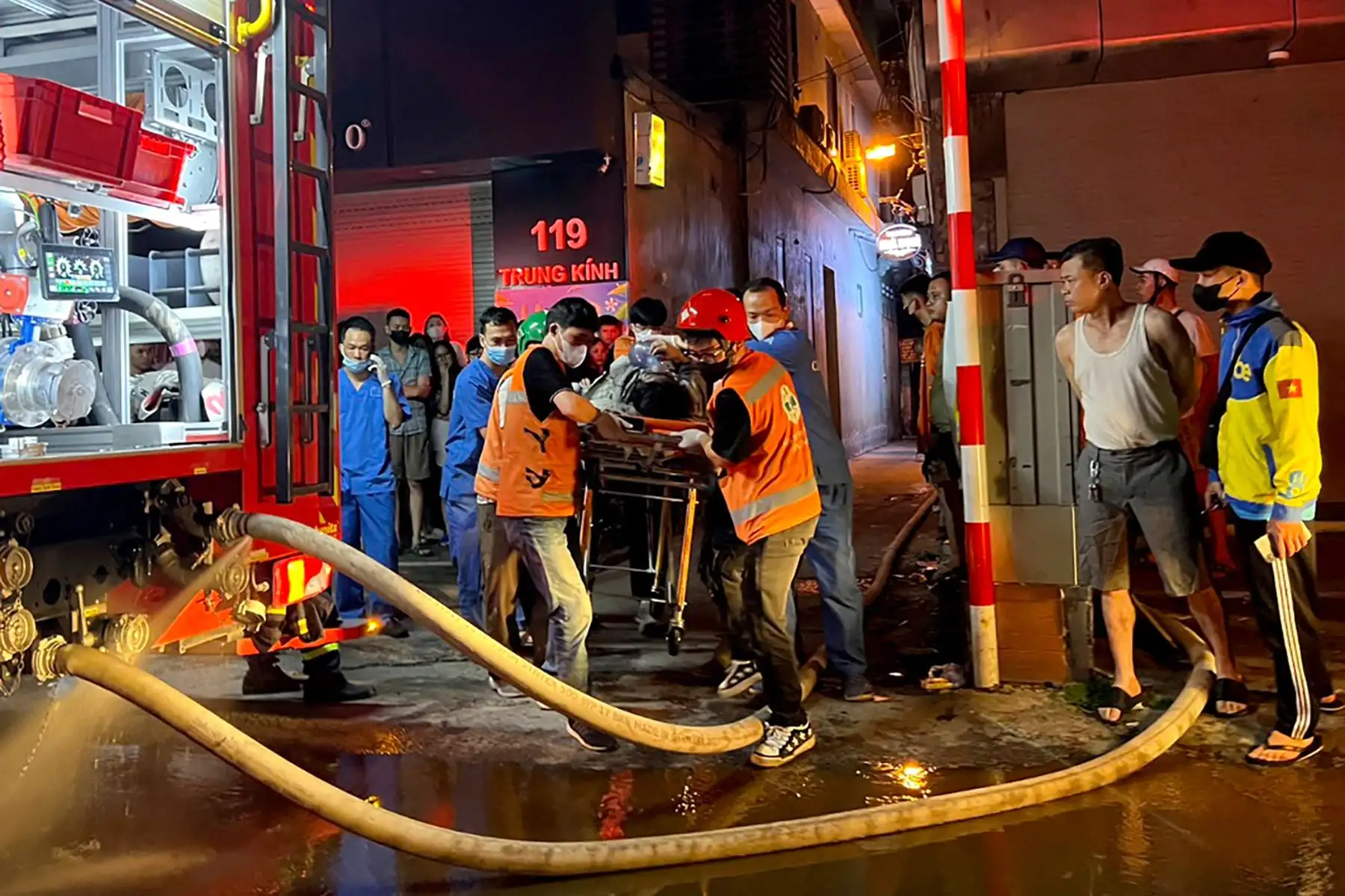 Los trabajadores de Bomberos y Rescate llevan a una víctima a una ambulancia tras un gran incendio en un bloque de apartamentos en Hanoi. Un incendio que arrasó un pequeño bloque de apartamentos en el centro de Hanoi mató al menos a 14 personas e hirió a otras tres, dijeron los medios estatales. Foto: AFP