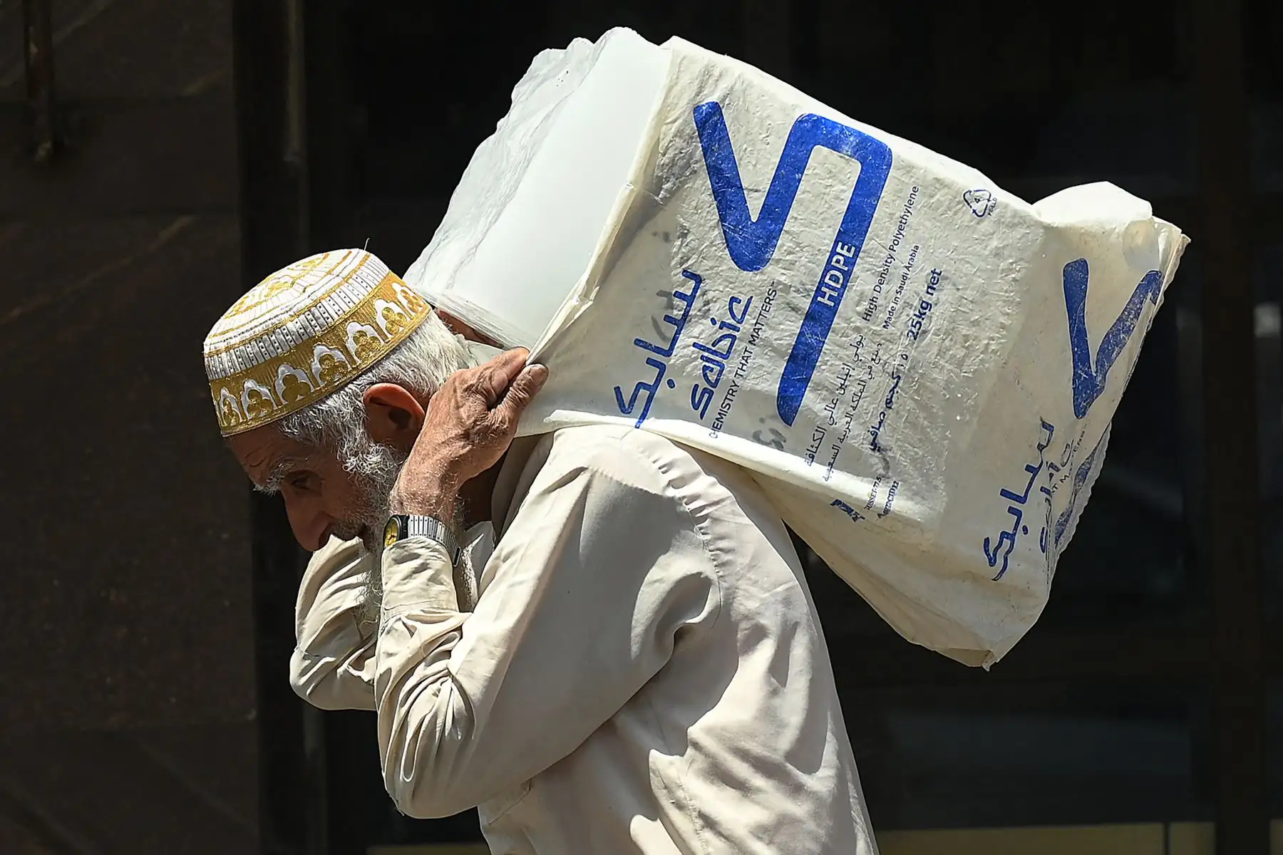 Un anciano lleva hielo en la espalda a lo largo de una carretera durante un caluroso día de verano en Rawalpindi. El Departamento Meteorológico de Pakistán dijo que se espera que las temperaturas alcancen los 50 grados Celsius en partes de la zona rural de Sindh. Foto: AFP