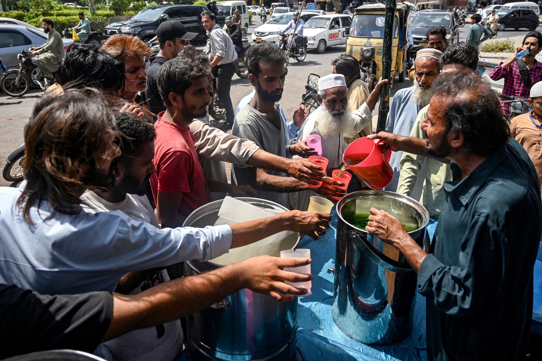 Un voluntario distribuye bebidas frías a los transeúntes en un campamento de ayuda para la ola de calor en Karachi. Se han establecido más de 1000 campamentos en la provincia de Sindh, en el sur de Pakistán. Foto: AFP