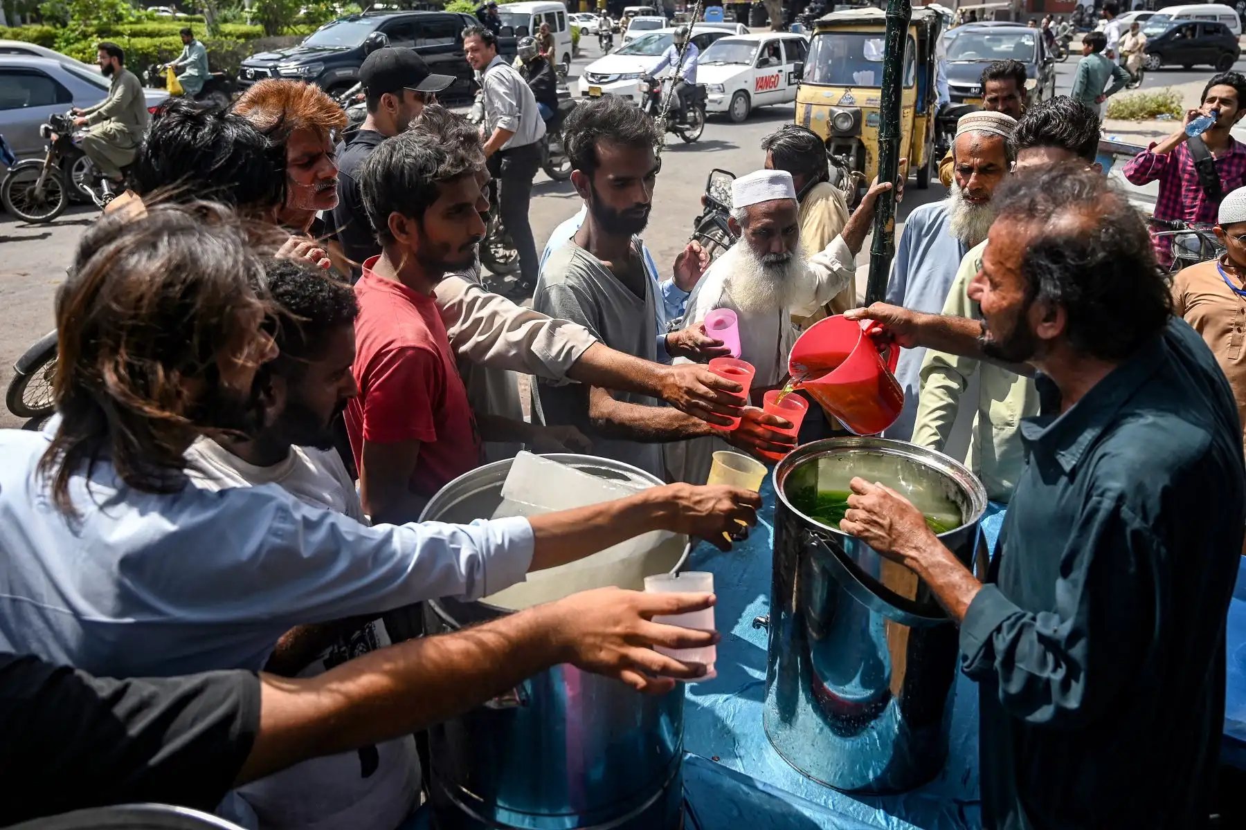 Un voluntario distribuye bebidas frías a los transeúntes en un campamento de ayuda para la ola de calor en Karachi. Se han establecido más de 1000 campamentos en la provincia de Sindh, en el sur de Pakistán. Foto: AFP