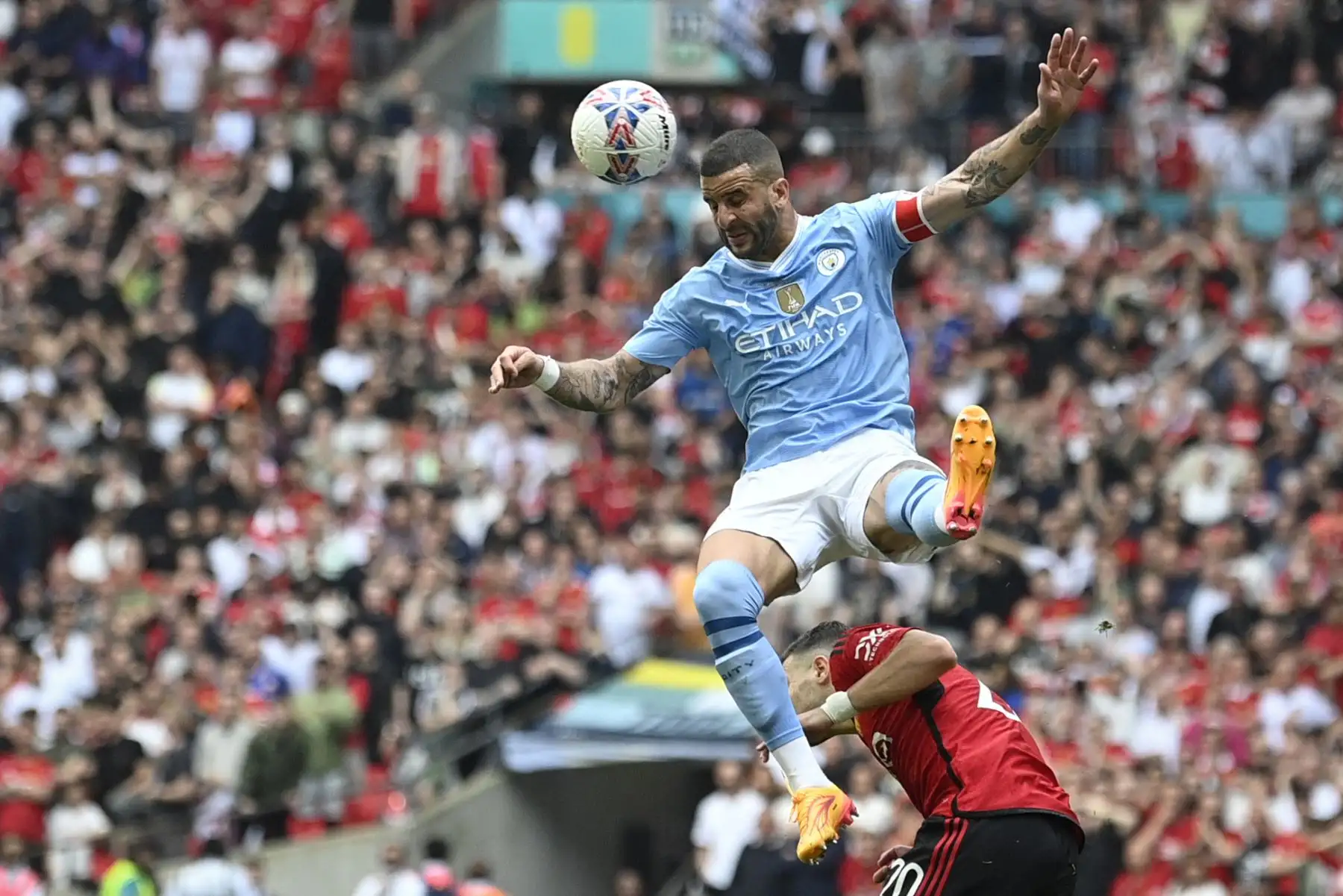 El defensor inglés del Manchester City Kyle Walker salta para cabecear el balón sobre el defensor portugués del Manchester United  Diogo Dalot durante el partido de fútbol final de la Copa FA inglesa entre Manchester City y Manchester United.  Foto: ANDINA/AFP