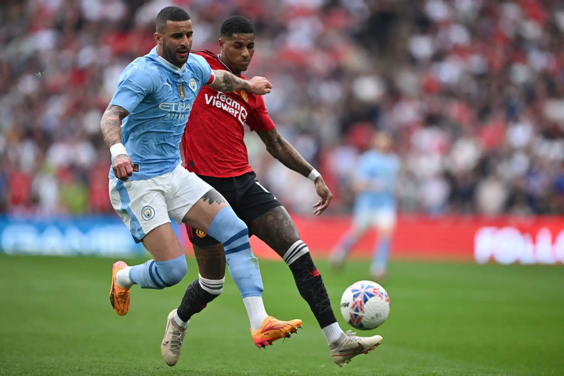 El defensor inglés del Manchester City  Kyle Walker lucha por el balón con el delantero inglés del Manchester United  Marcus Rashford durante el partido de fútbol final de la Copa FA inglesa entre Manchester City y Manchester United. Foto: ANDINA/AFP