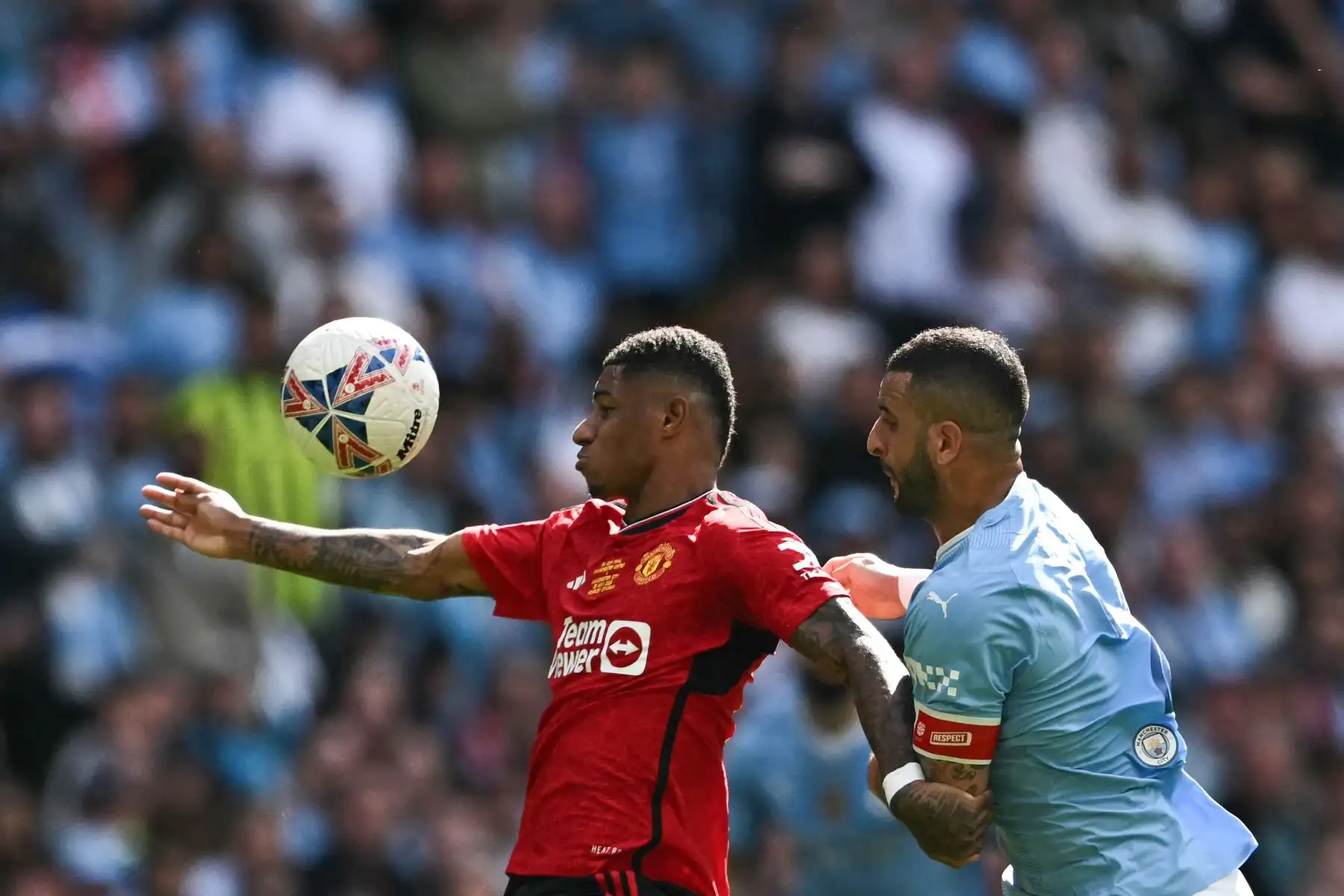 El defensor inglés del Manchester City Kyle Walker lucha por el balón con el delantero inglés del Manchester United  Marcus Rashford durante el partido de fútbol final de la Copa FA inglesa entre Manchester City y Manchester United. Foto: ANDINA/AFP