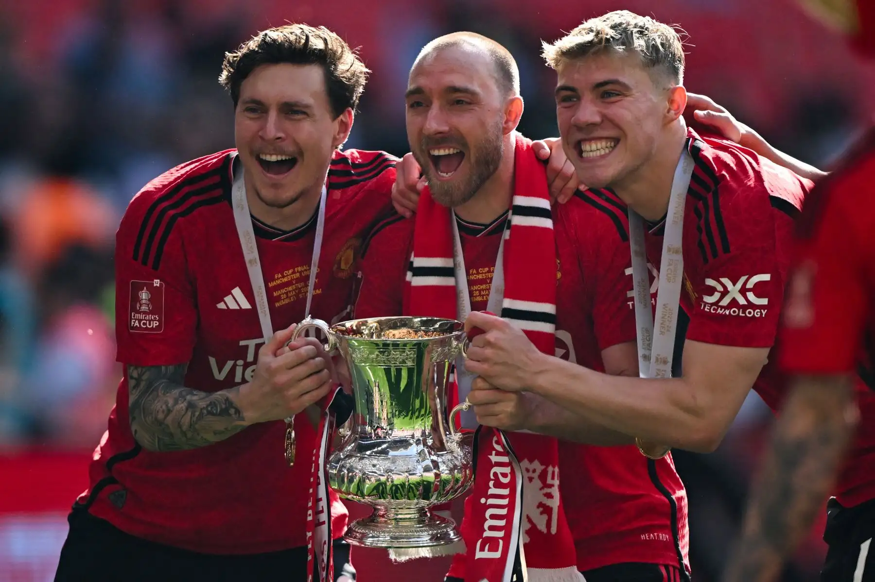 El defensor sueco del Manchester United Victor Lindelof, el mediocampista danés del Manchester United  Christian Eriksen y el delantero danés del Manchester United  Rasmus Hojlund celebran con el trofeo después de ganar al final de la final de la Copa FA inglesa entre el Manchester City y Manchester United. Foto: ANDINA/AFP