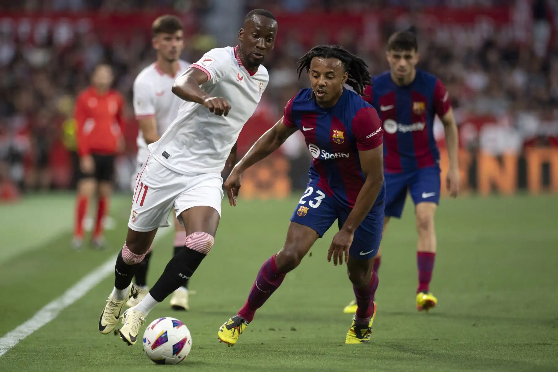 El delantero belga del Sevilla  Dodi Lukebakio y el defensor francés del Barcelona #23 Jules Kounde compiten por el balón durante el partido de fútbol de la liga española entre el Sevilla FC y el FC Barcelona. 
Foto. ANDINA/AFP