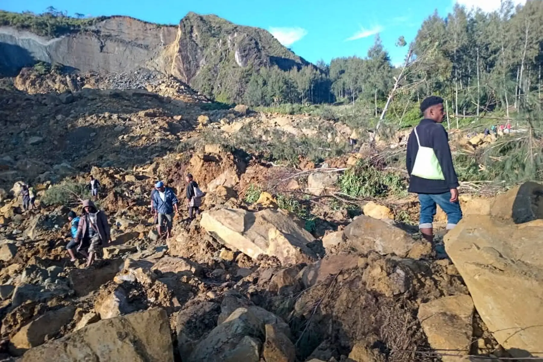 La gente se reúne en el lugar de un deslizamiento de tierra en Maip Mulitaka, en la provincia de Enga, Papúa Nueva Guinea. Funcionarios locales y grupos de ayuda dijeron que un deslizamiento de tierra masivo azotó una aldea en las tierras altas de Papúa Nueva Guinea. AFP