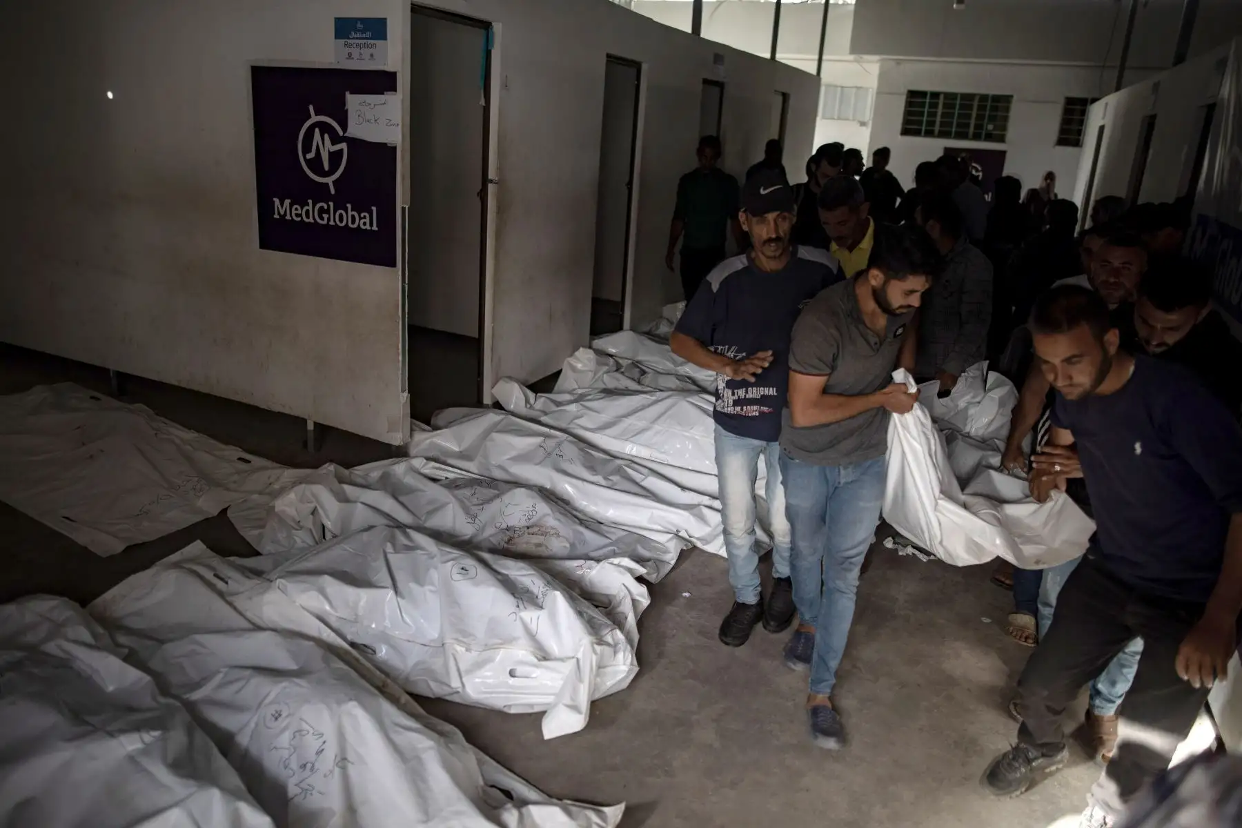 Los palestinos cargan cadáveres después de una incursión del ejército israelí en un campamento en una zona designada para los desplazados en Rafah, en el sur de la Franja de Gaza. Foto: EFE
