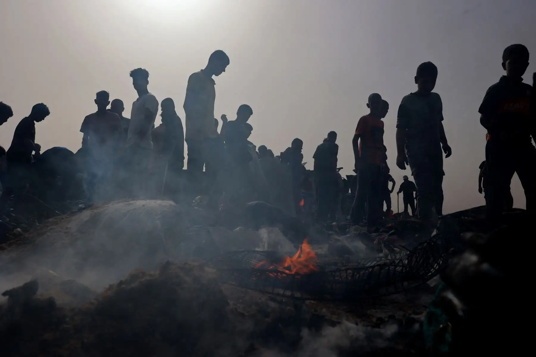 Los palestinos se reúnen en el lugar de un ataque israelí contra un campamento para desplazados internos en Rafah. Foto: AFP