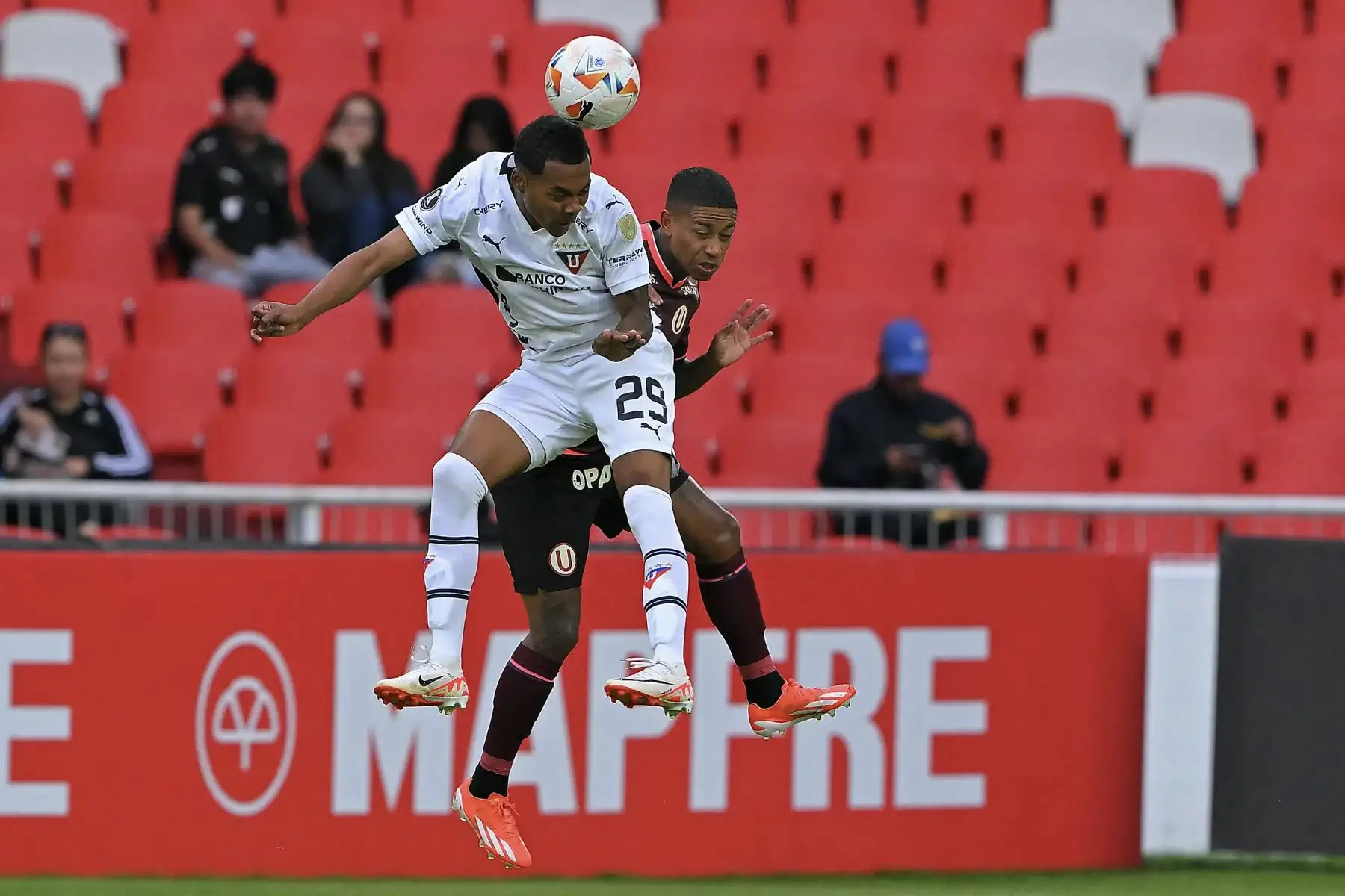 El defensor de la Liga de Quito, Bryan Ramírez (i), y el delantero del Universitario, Andy Polo, luchan por el balón durante el partido de fútbol de vuelta de la fase de grupos de la Copa Libertadores. Foto: AFP
