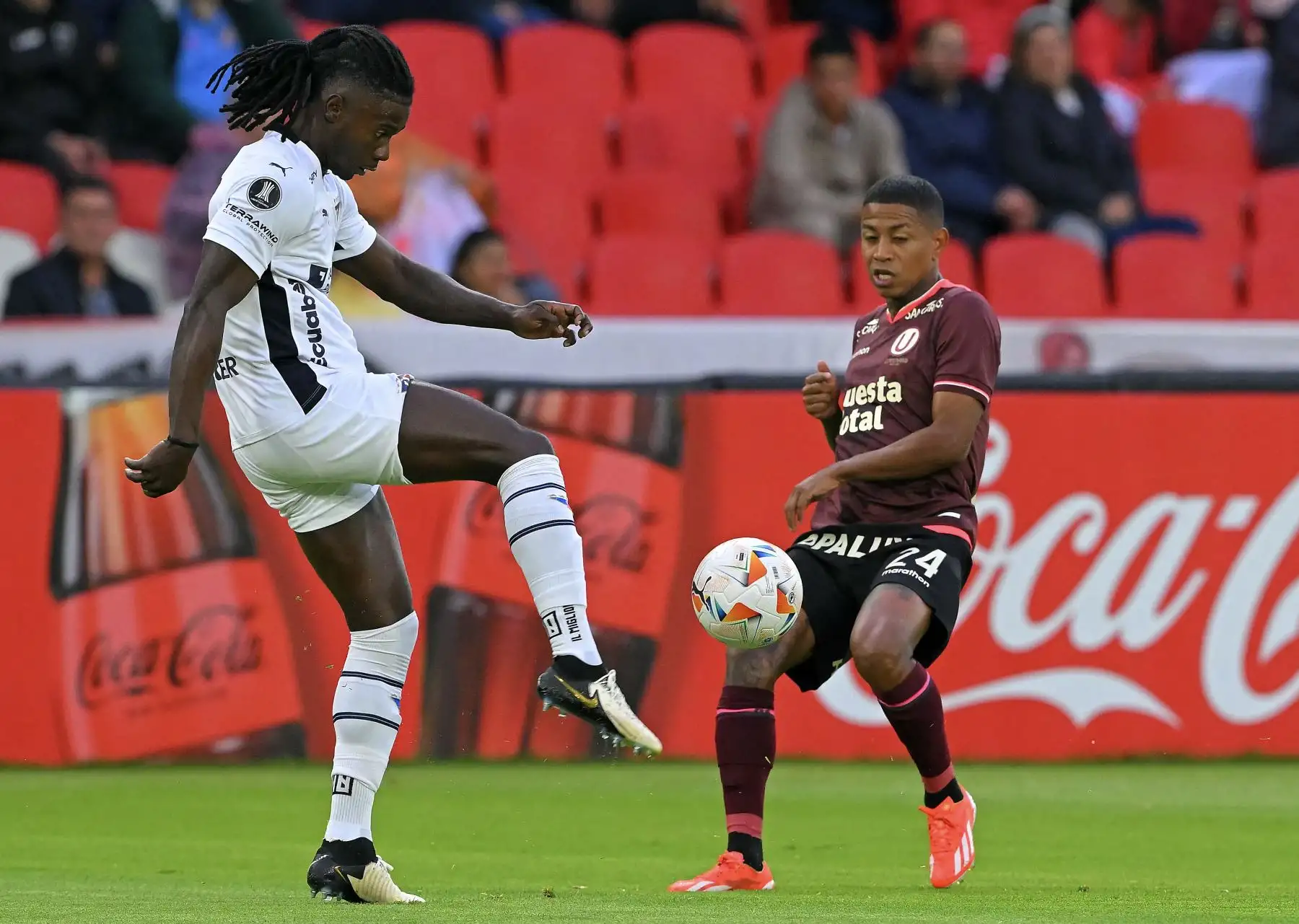 El defensor haitiano de Liga de Quito Ricardo Ade (i) y el delantero de Universitario Andy Polo luchan por el balón durante el partido de vuelta de la fase de grupos de la Copa Libertadores entre la Liga de Quito de Ecuador y Universitario de Perú en el estadio Rodrigo Paz Delgado de Quito. Foto: AFP