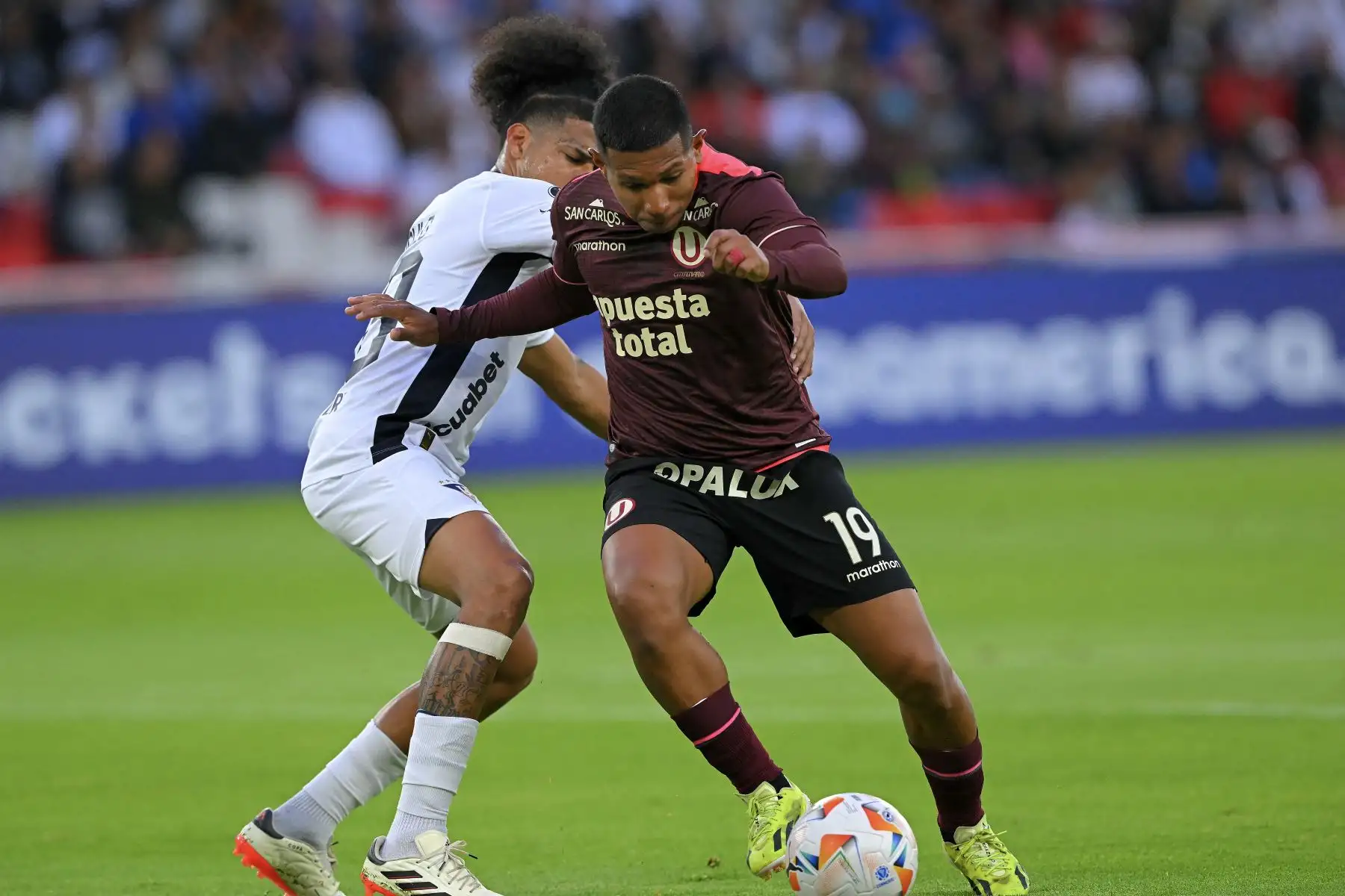 El defensor de la Liga de Quito, José Quintero (i), y el delantero del Universitario, Alex Valera, luchan por el balón durante el partido de fútbol de vuelta de la fase de grupos de la Copa Libertadores entre la Liga de Quito de Ecuador y el Universitario de Perú. Foto: AFP