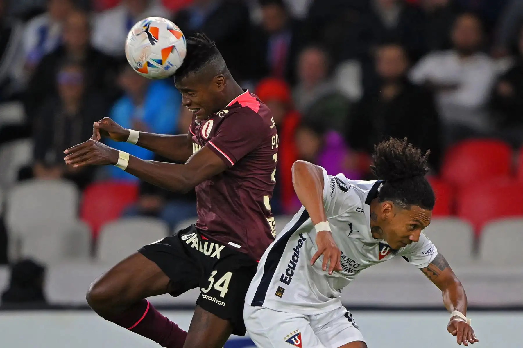 El defensor ecuatoriano de Universitario Segundo Portocarrero (L) y el defensor de la Liga de Quito José Quintero luchan por el balón durante el partido de vuelta de la fase de grupos de la Copa Libertadores entre la Liga de Quito de Ecuador y el Universitario de Perú en el Estadio Rodrigo Paz Delgado en Quito, el 28 de mayo. 2024. Foto: AFP