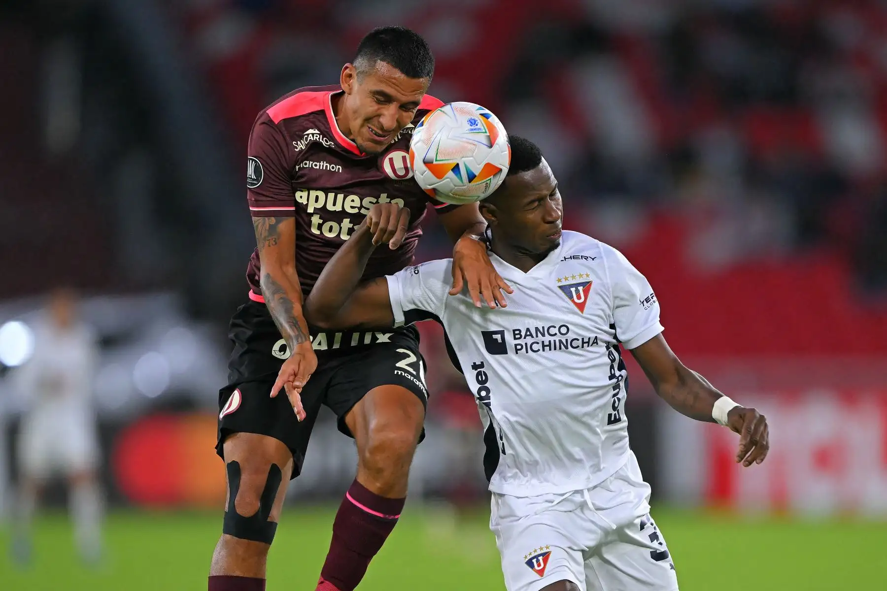 El delantero de Universitario Alex Valera (L) y el defensor de la Liga de Quito Leonel Quiñonez luchan por el balón durante el partido de fútbol de vuelta de la fase de grupos de la Copa Libertadores entre la Liga de Quito de Ecuador y el Universitario de Perú en el Estadio Rodrigo Paz Delgado en Quito, el 28 de mayo de 2024. Foto: AFP
