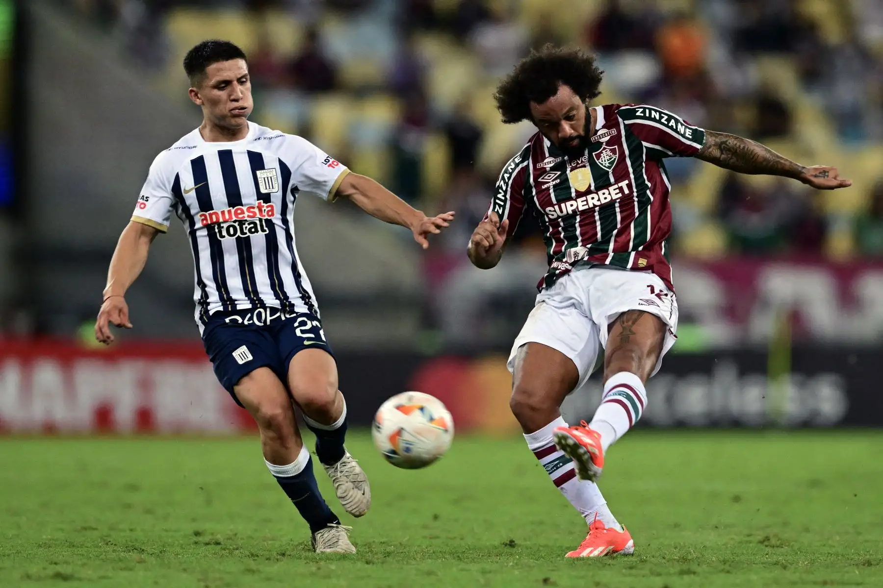 El mediocampista de Alianza Lima, Catriel Cabellos  y el defensor de Fluminense, Marcelo, luchan por el balón durante el partido de vuelta de la fase de grupos de la Copa Libertadores entre el Fluminense de Brasil y Alianza Lima de Perú en el Estadio Maracaná de Río de Janeiro, Brasil.
Foto: AFP