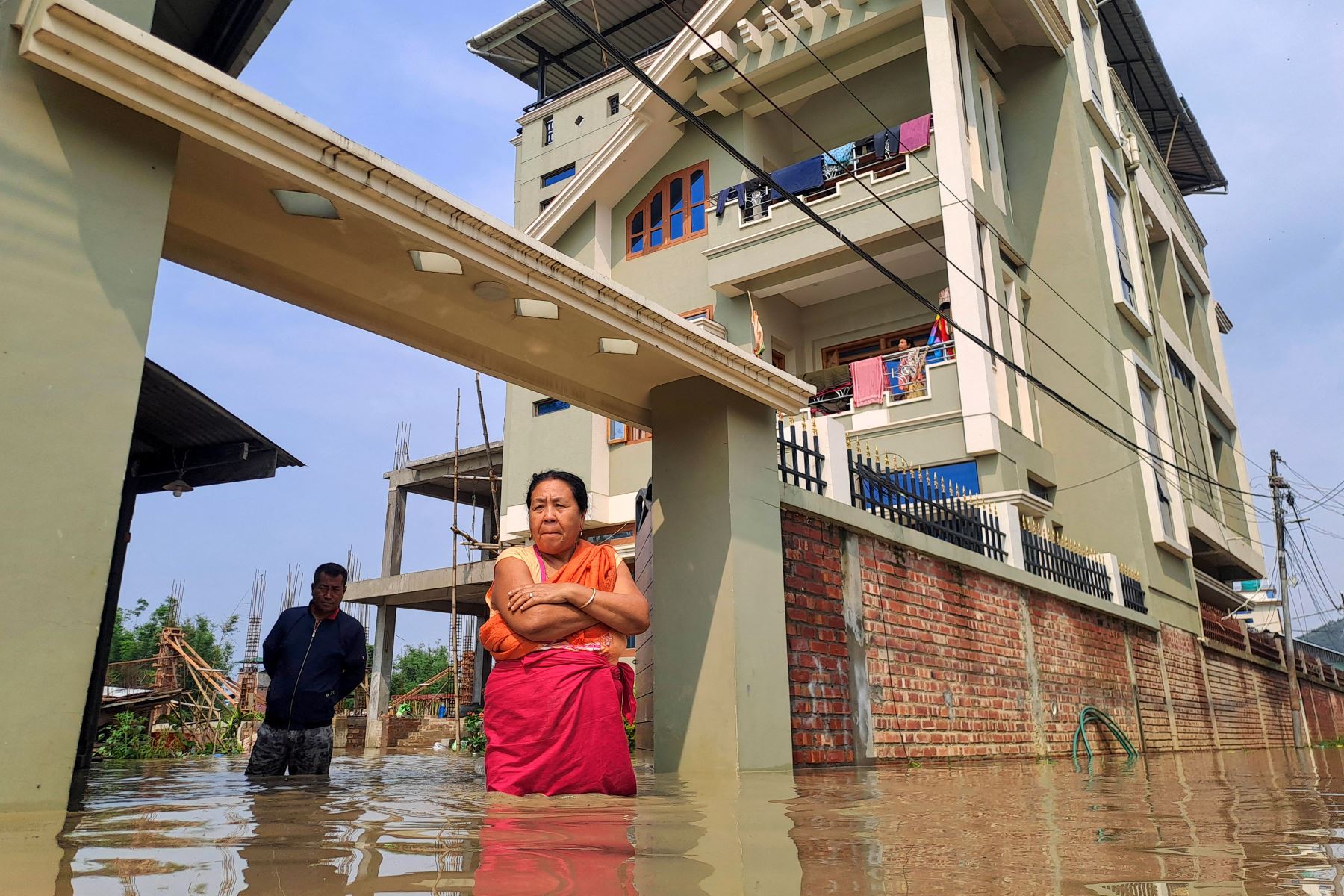 La gente camina por una calle inundada después de las fuertes lluvias después de que el ciclón Remal tocara tierra en Imphal, en el estado de Manipur, La India. Un poderoso ciclón que azotó las zonas bajas de Bangladesh e India mató al menos a 65 personas, incluidas tormentas de lluvia torrenciales a su paso. Foto: AFP