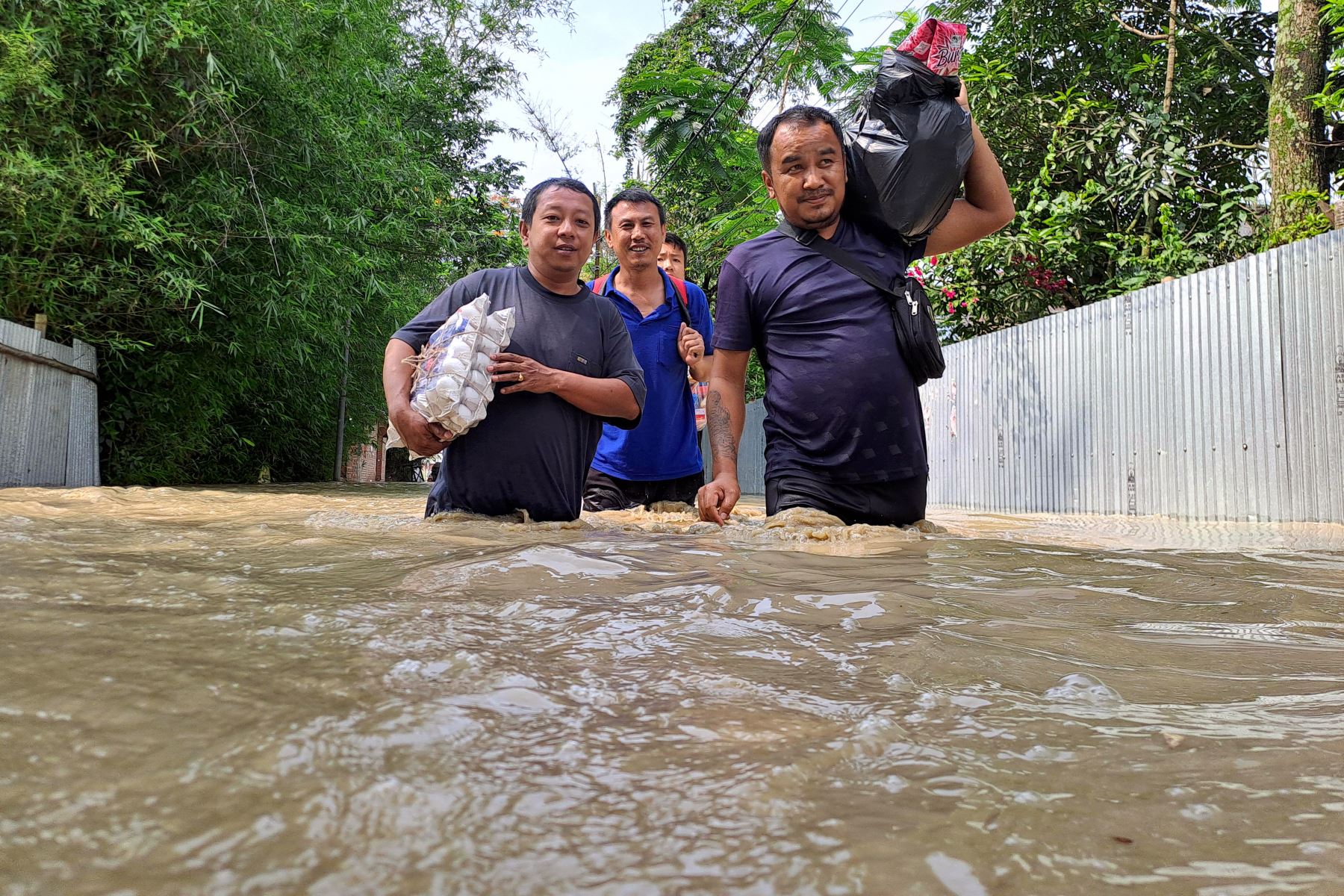 La gente camina por una calle inundada tras las fuertes lluvias por la llegada del ciclón Remal a Imphal, en el estado de Manipur, La India. Foto: AFP