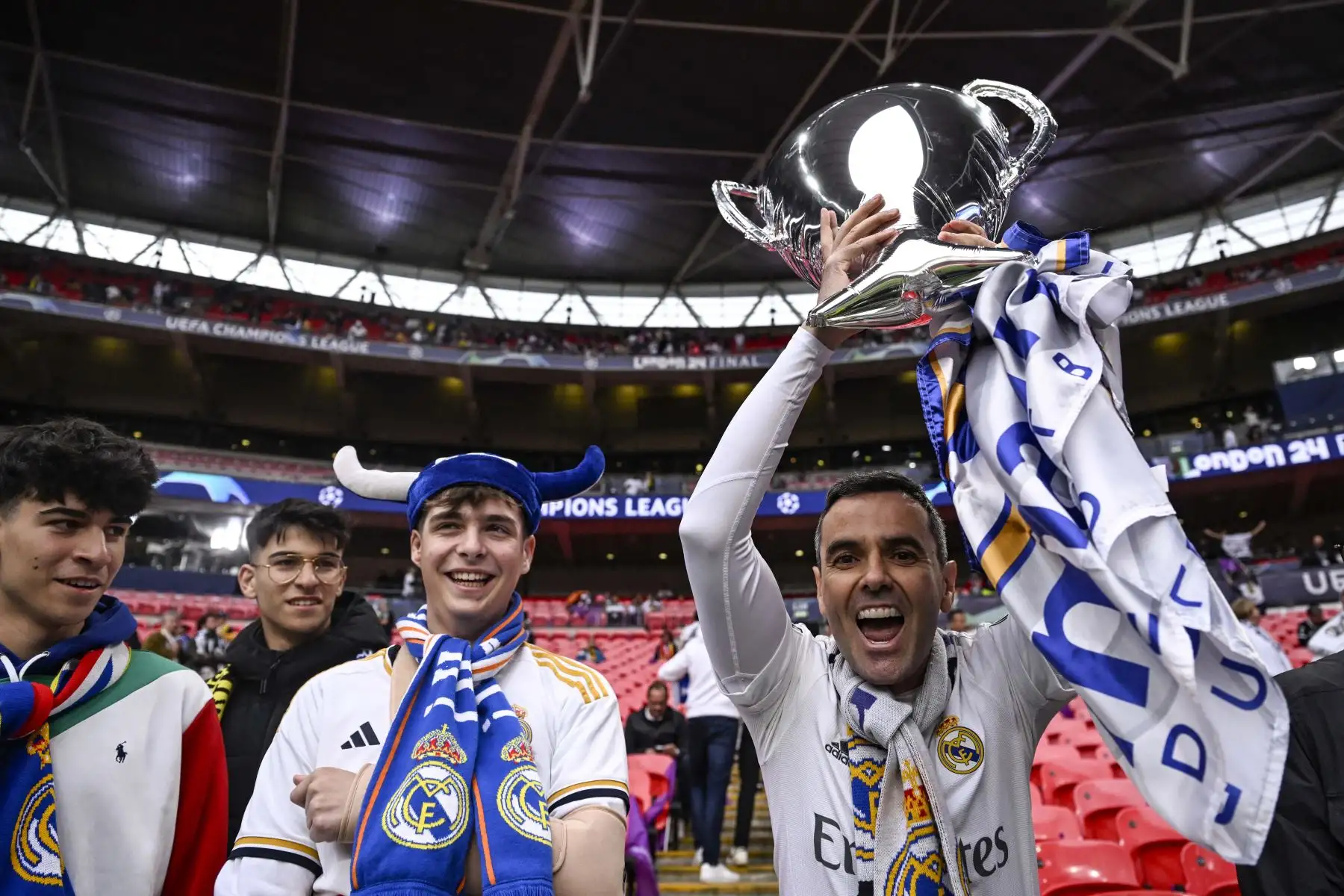 Los seguidores del Real Madrid sostienen un globo de helio con forma de trofeo en el estadio de Wembley, en Londres, antes del partido de fútbol final de la Liga de Campeones de la UEFA entre el Borussia Dortmund y el Real Madrid. Foto: ANDINA/  AFP