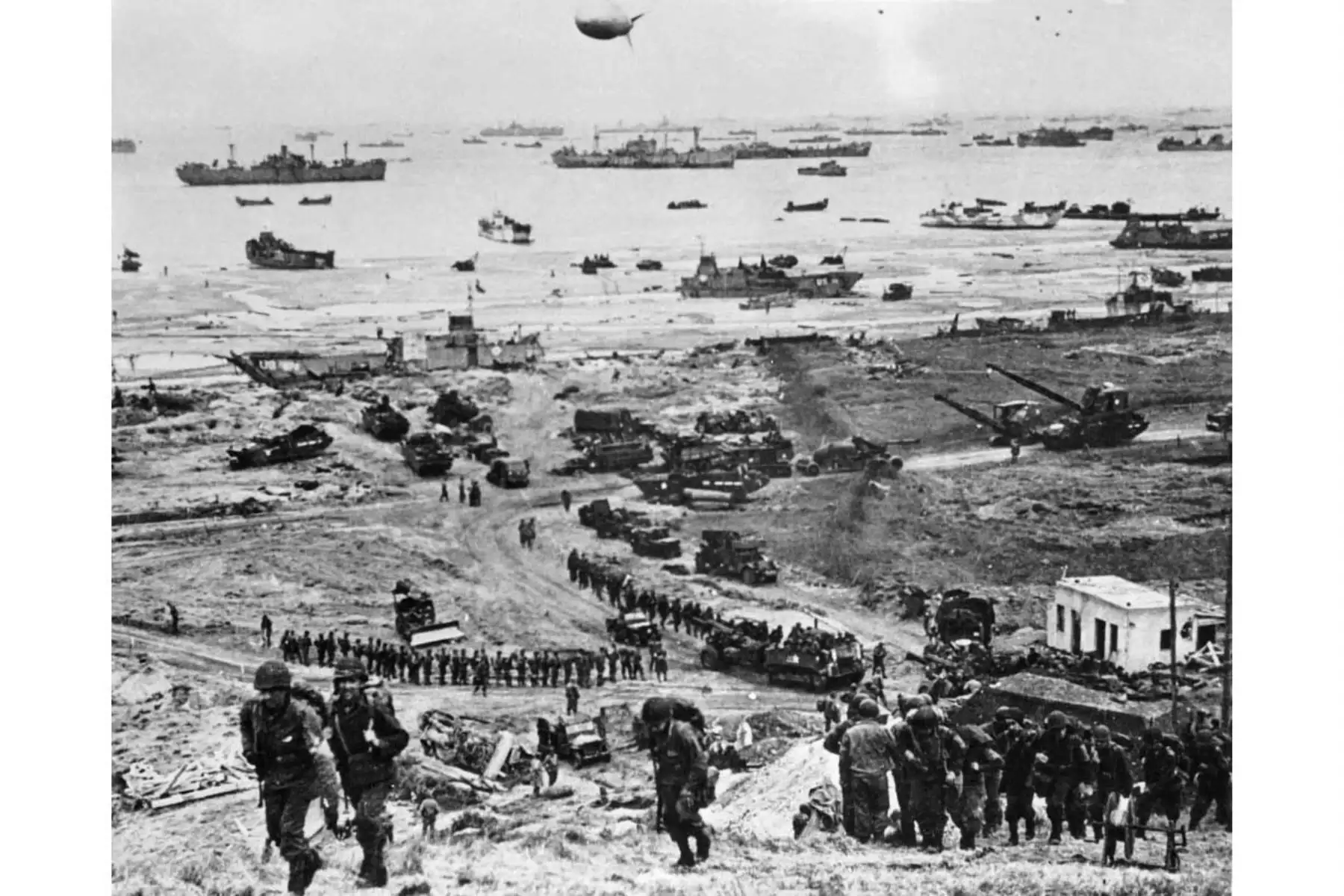 Fotografía tomada el 6 de junio de 1944 en Normandía que muestra a los soldados de las fuerzas aliadas involucrados en la operación de desembarco destinada a luchar contra la Wehrmacht alemana como parte de la Segunda Guerra Mundial. En lo que sigue siendo el mayor asalto anfibio de la historia, unos 156.000 efectivos aliados desembarcaron en Francia el 6 de junio de 1944. Se estima que 10.000 soldados aliados quedaron muertos, heridos o desaparecidos, mientras que la Alemania nazi perdió entre 4.000 y 9.00
