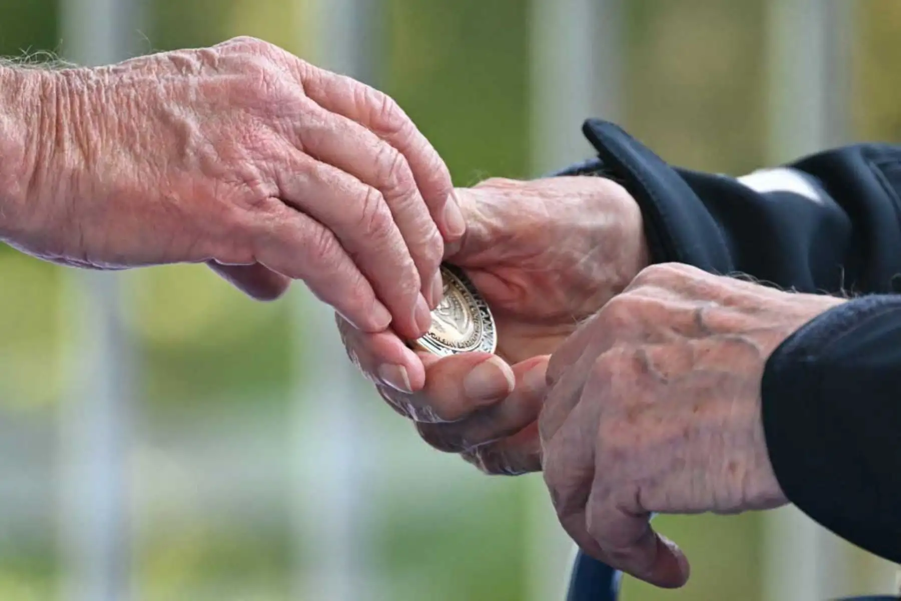 El presidente de los Estados Unidos, Joe Biden, coloca una moneda de desafío en las manos de un veterano estadounidense de la Segunda Guerra Mundial durante la ceremonia estadounidense que conmemora el 80.º aniversario del desembarco aliado del "Día D" de la Segunda Guerra Mundial en Normandía, en el Cementerio y Memorial Americano de Normandía en Colleville-sur. -Mer, con vistas a la playa de Omaha en el noroeste de Francia. Foto: AFP