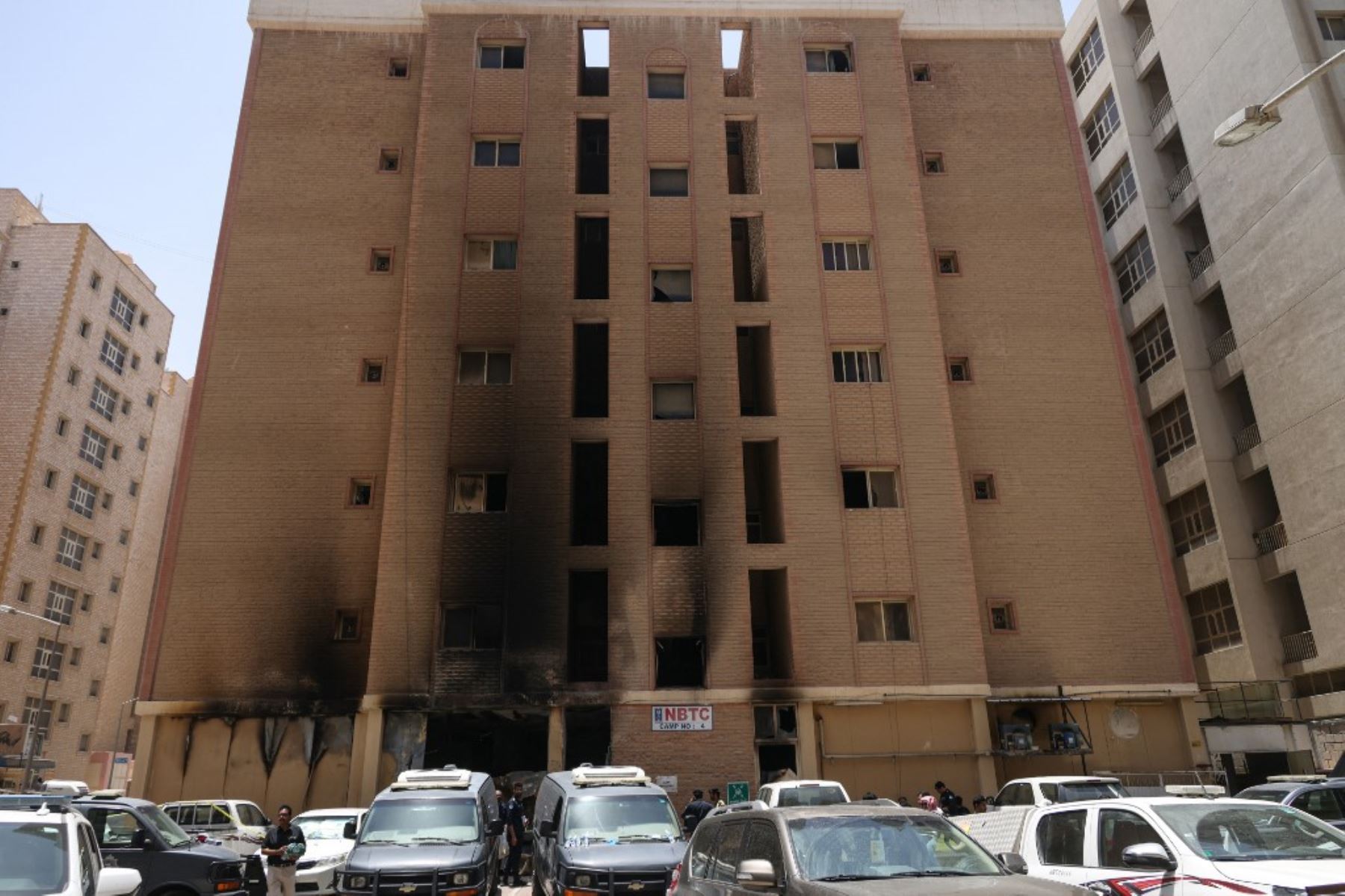 Las fuerzas de seguridad kuwaitíes se reúnen frente a un edificio que fue devorado por un incendio, en la ciudad de Kuwait. Foto: AFP