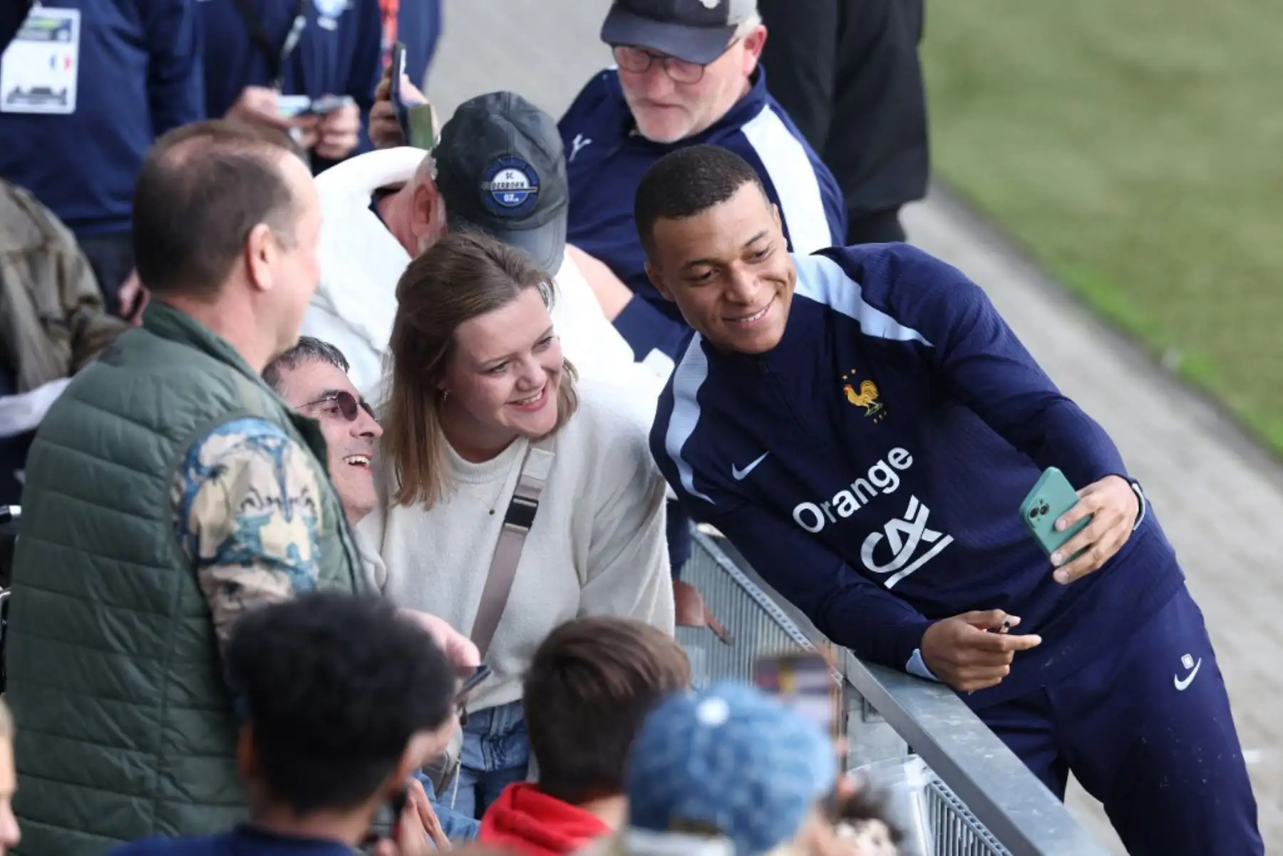 El delantero francés Kylian Mbappé se toma una selfie con los fanáticos al final de una sesión de entrenamiento en el estadio Home Deluxe Arena en Paderborn, oeste de Alemania, antes del campeonato de fútbol UEFA Euro 2024. Foto: AFP