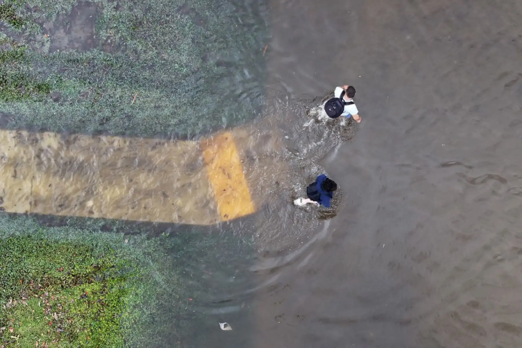 Vista aérea, la gente camina por una calle inundada, en Hallandale Beach, Florida. A medida que la humedad tropical pasa por la zona, algunas zonas se han inundado debido a las fuertes lluvias. Foto: AFP