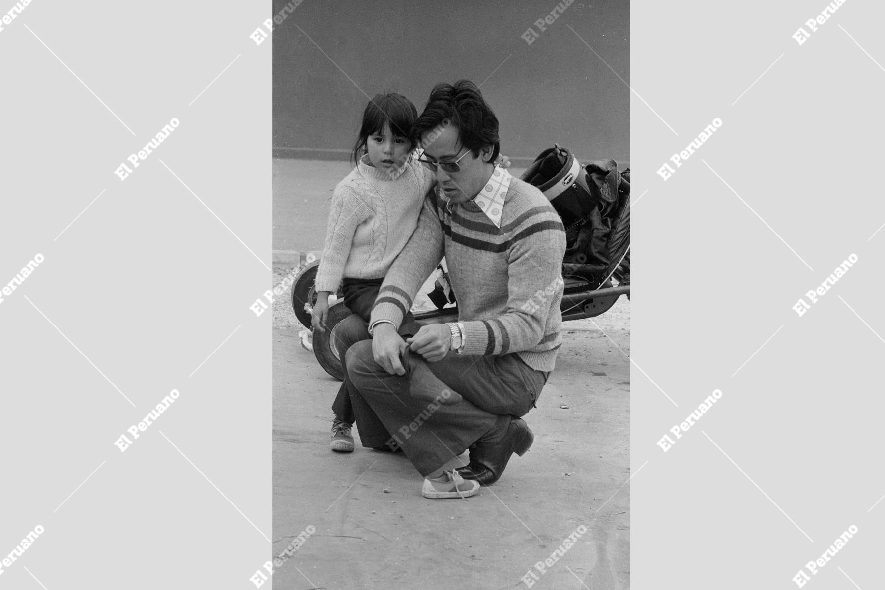 Lima - 19 setiembre 1976 / En el marco de la Feria del Pacifico, padre de familia detenidamente  acomoda la media de su menor hija. Foto: Archivo Histórico El Peruano